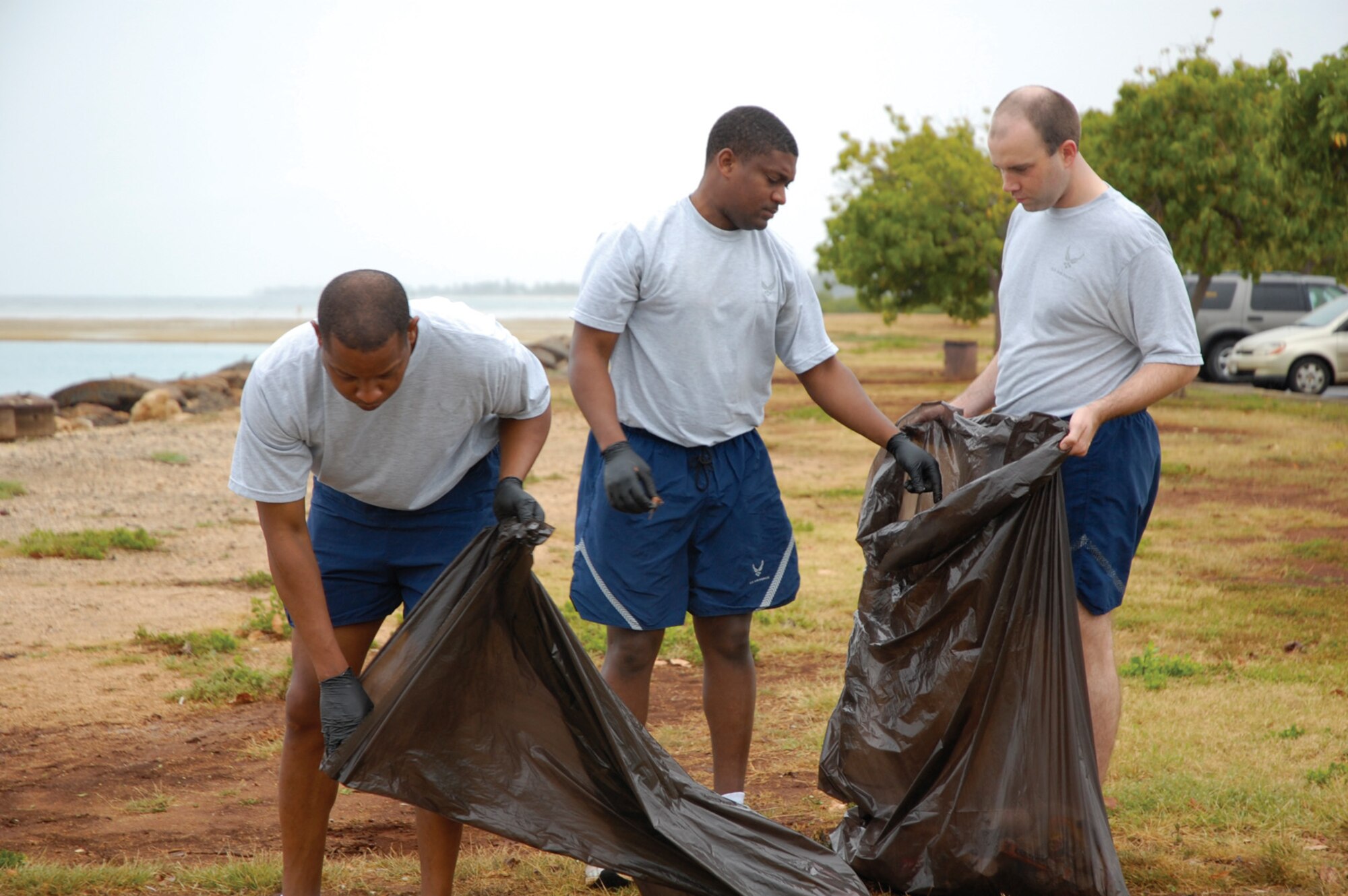 HICKAM AIR FORCE BASE, Hawaii -- Master Sgt. Farrell Thomas, Staff Sgt. Terrob Cook, and Senior Airman Ryan Bruce from the 15th Mission Support Squadron fill trash bags during the April 23 “Polishing the Pearl of the Pacific” clean up. Among their haul were “hundreds” of cigarette butts, numerous recyclable containers and — said a surprised Sergeant Thomas — disposable floss picks. “They believe in hygiene but don’t believe in throwing this away,” he commented holding a sullied pick. “We also found an old car battery, which we promptly turned over to the environmental specialists,” said their commander, Maj. Steven Zubowicz. “I sincerely hope people have a better appreciation in being responsible with their trash and disposing of it properly.” According to the 15th Civil Engineer Squadron, which lead the effort, more than 500 personnel participated in the cleanup, bringing in more that 150 bags of debris and other bulk trash items. The hard work was in preparation for the COMPACAF’s Commander’s Conference. (Photo by Chris Aguinaldo, Hickam Kukini editor)
