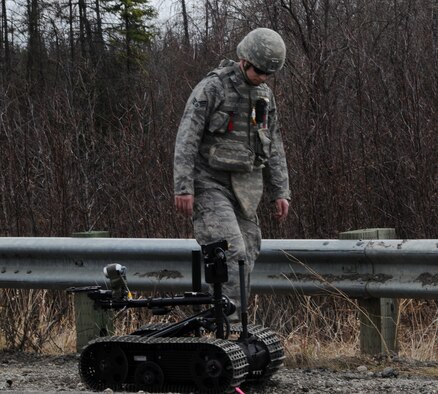 Senior Airman Edwin Fortier walks alongside a Talon after a training mission May 5 at Eielson Air Force Base, Alaska. Military personnel train with the Talon, a tactical robot used to assist in de-arming improvised explosive devises from a safe distance. Airman Fortier is an explosive ordinance disposal apprentice with the 354th Civil Engineer Squadron Explosive Ordnance Flight. (U.S. Air Force photo/Airman 1st Class Laura Max) 