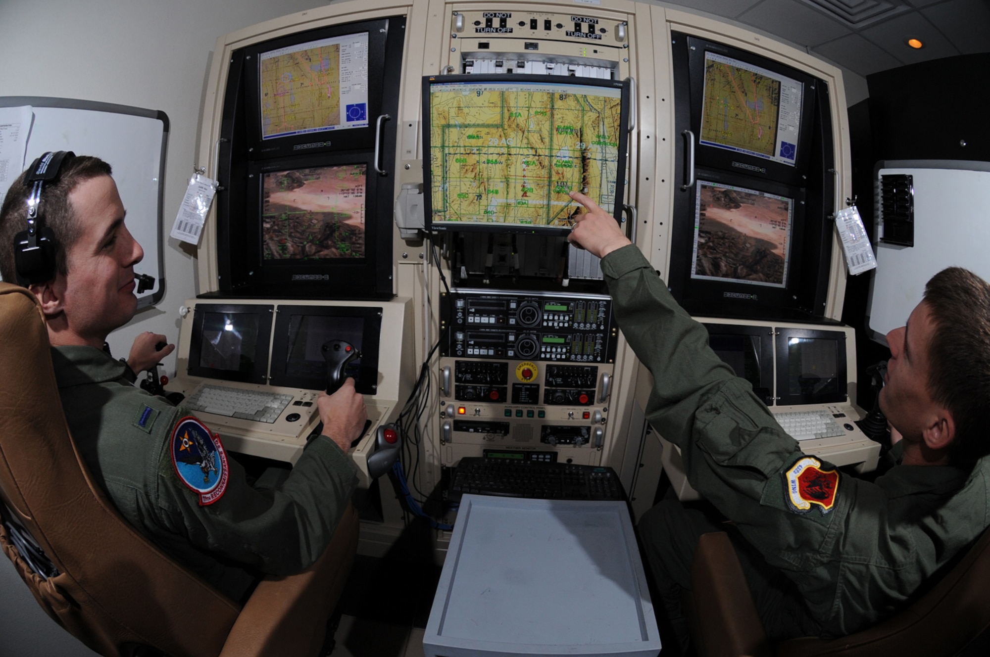 CREECH AFB, Nev. -- Airman 1st Class Caleb Force, a MQ-1B Predator student sensor operator, assists 1st Lt. Jordan Smith, a MQ-1B Predator student Pilot, in locating simulated targets during a training mission conducted inside the simulators at Creech April 22. Both are assigned to the 11th Reconnaissance Squadron. (U.S. Air Force photo by/Senior Airman Nadine Y. Barclay)