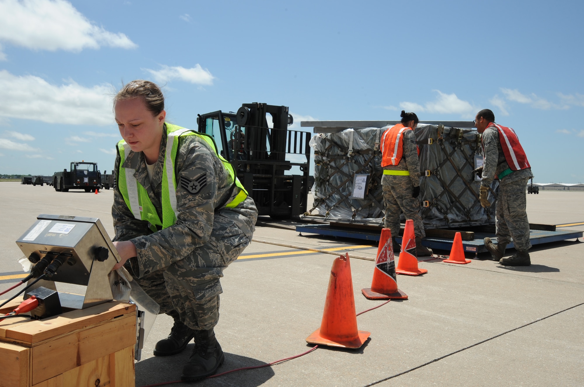 MCCONNELL AIR FORCE BASE, Kan. -- Staff Sgt. Amanda Hartman, 22nd Logistics Readiness Squadron, checks the weight of a cargo pallet on the flight line during an operational readiness exercise, May 6. While Sergeant Hartman checks the pallet’s weight, Senior Airman Millicent Yusi and Airman 1st Class Gregory Sena, 22nd Logistics Readiness Squadron, ensure the pallet straps are tightly buckled and that the pallet is placed correctly on the scale. (Photo by Senior Airman Laura Suttles