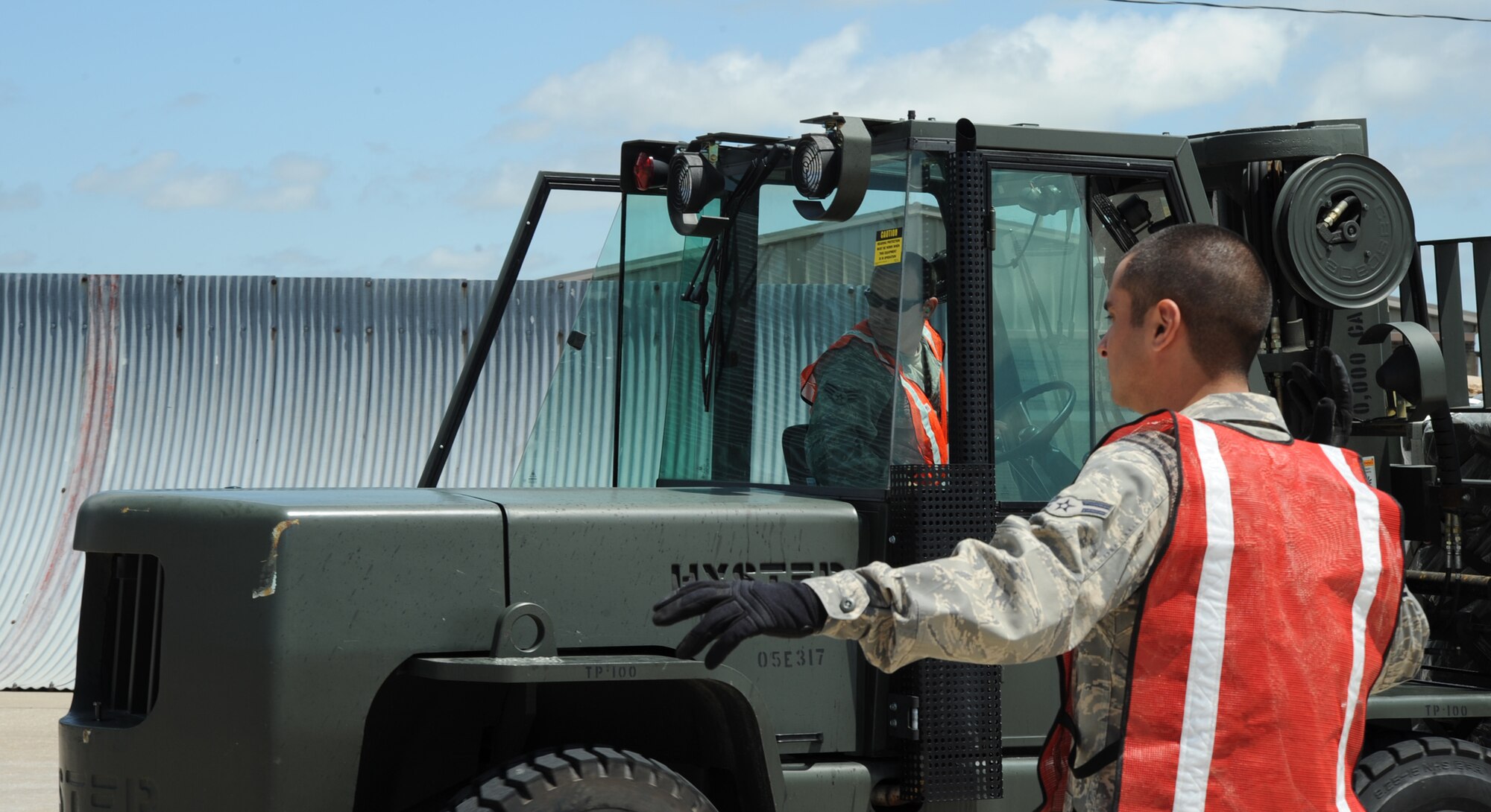 MCCONNELL AIR FORCE BASE, Kan. -- Airman 1st Class David Ferreira, 22nd Logistics Readiness Squadron, guides Senior Airman Tyler Overman, 22nd Logistics Readiness Squadron, as Airman Overman backs up a 10-K Forklift in the cargo deployment function yard, May 6. The Airmen moved multiple pallets loaded with Air Force cargo during an operational readiness exercise to ensure mission capabilities soar beyond standards. (Photo by Senior Airman Laura Suttles)