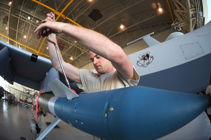 CREECH AFB, Nev. -- Senior Airman Jason Atwell, a MQ-9 Reaper weapons loader assigned to the 432d Aircraft Maintenance Squadron, secures the fins on a GBU-12 Paveway II laser-guided bomb during weapons load training at Creech April 22. (U.S. Air Force photo/Senior Airman Larry E. Reid Jr.)