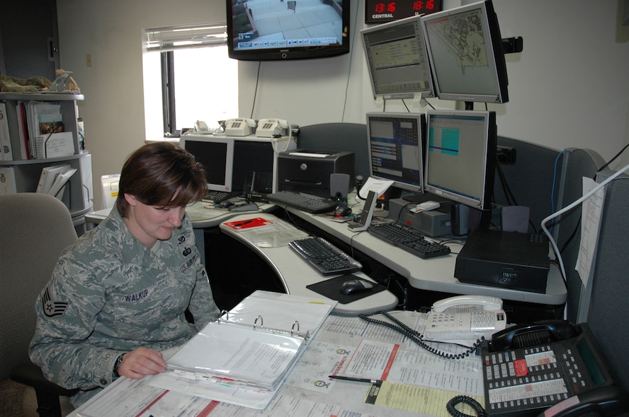 MINOT AIR FORCE BASE, N.D. -- Staff Sgt. Sherry Walkup, 5th Civil Engineer Squadron alarm room dispatcher goes over a checklist at the emergency dispatch center here May 5. The EDC is the frontline of response and assistance for many emergency situations on the base. (U.S. Air Force photo by Senior Airman Wesley Wright)