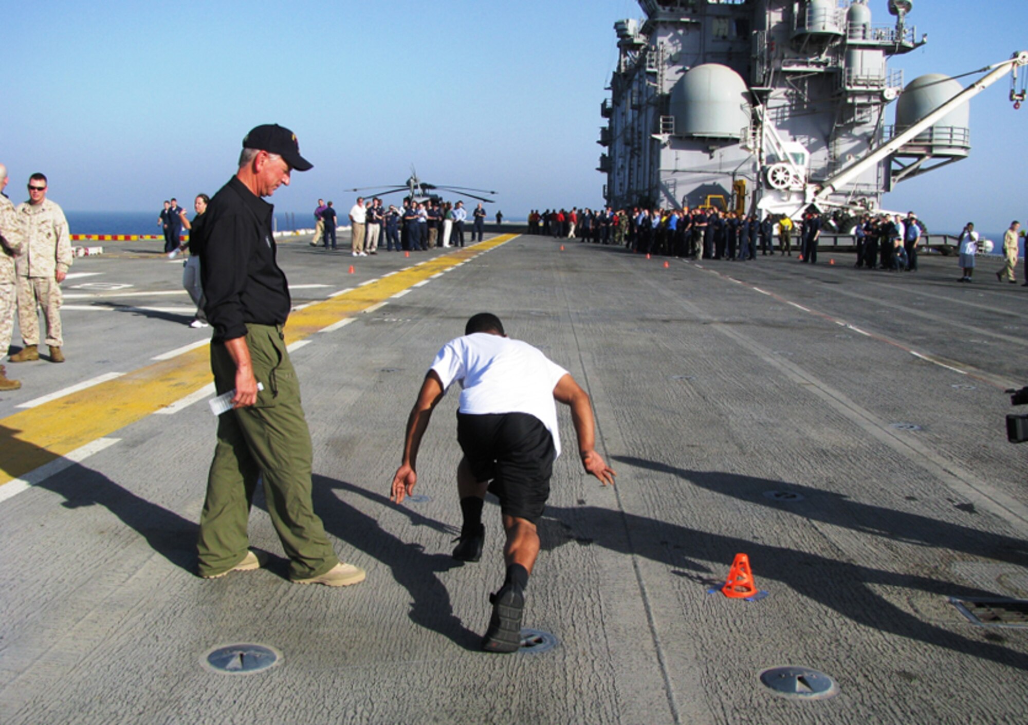 Coach Emeritus Tommy Tuberville watches a sailor test his speed during a coach/player combine aboard a U.S. Navy ship near Soutwest Asia in 2008. The event is scheduled again this year during Coaches Tour 2009, a morale-boosting mission designed to bring NCAA football coaches to troops overseas. Like last year, tour organizers are counting on a KC-135 Stratotanker from McConnell Air Force Base, Kan., for most of their transportation needs. (Courtesy photo)