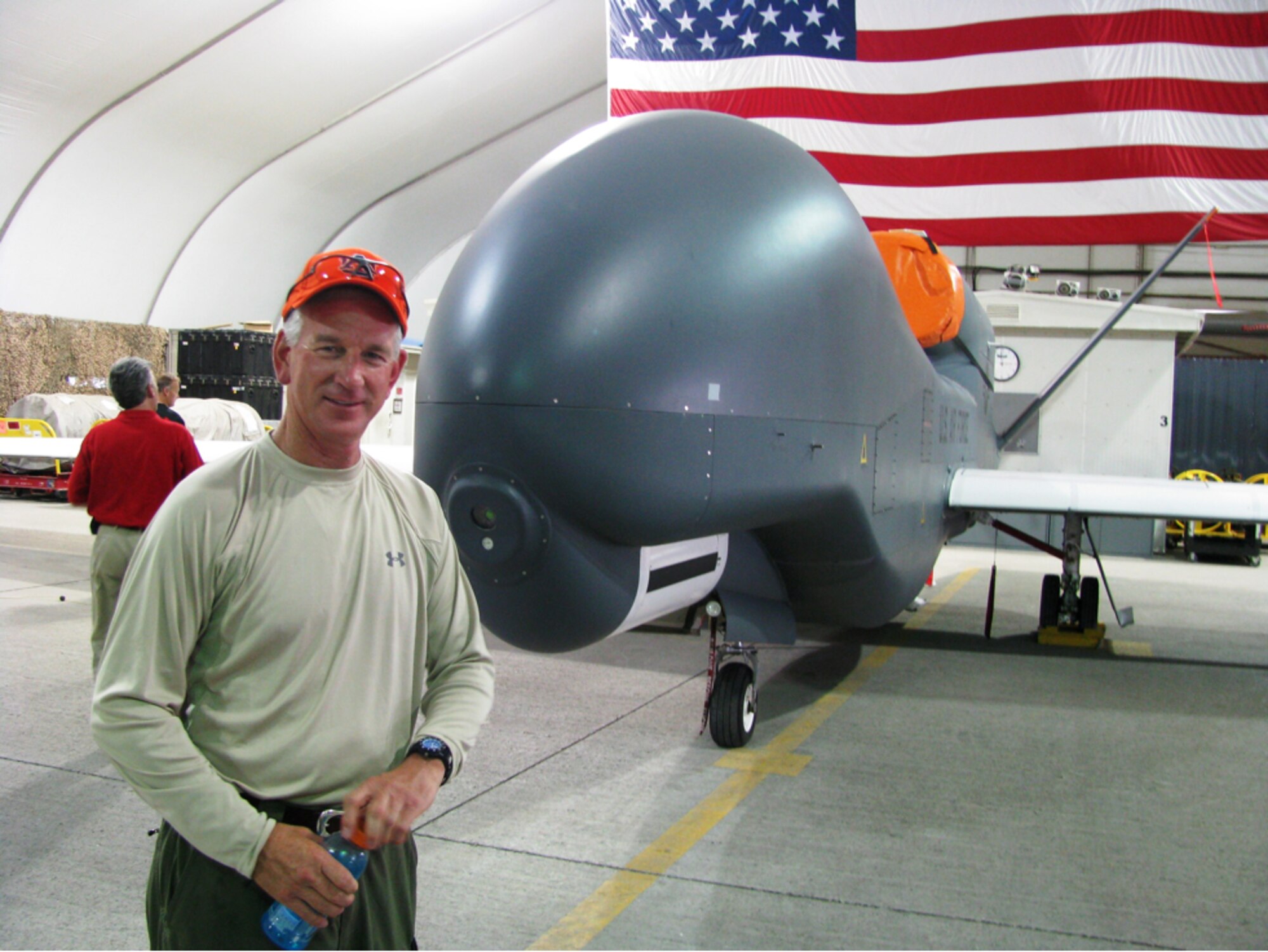 Coach Emeritus Tommy Tuberville stands next to a Global Hawk unmanned aerial vehicle in Southwest Asia during Coaches Tour 2008, a morale-boosting mission designed to bring NCAA football coaches to troops overseas. Tuberville is scheduled to lead six more coaches during Coaches Tour 2009 when they visit troops in Europe and the Middle East. Like last year, tour organizers are counting on a KC-135 Stratotanker from McConnell Air Force Base, Kan., for most of their transportation needs. (Courtesy photo)