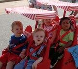Clients of Vance’s Child Development Center enjoy the ride during the Red, White & Blue Parade on base April 24, honoring the Month of the Military Child. (Photo by Melissa Seror)