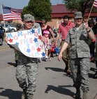 Lt. Col. David Stewart, left, 71st Mission Support Group deputy commander, along with Maj. Paul Johnston, 71st Force Support Squadron commander, lead Vance’s Child Development Center’s Red, White & Blue Parade on base April 24, honoring the Month of the Military Child. (Photo by Melissa Seror)