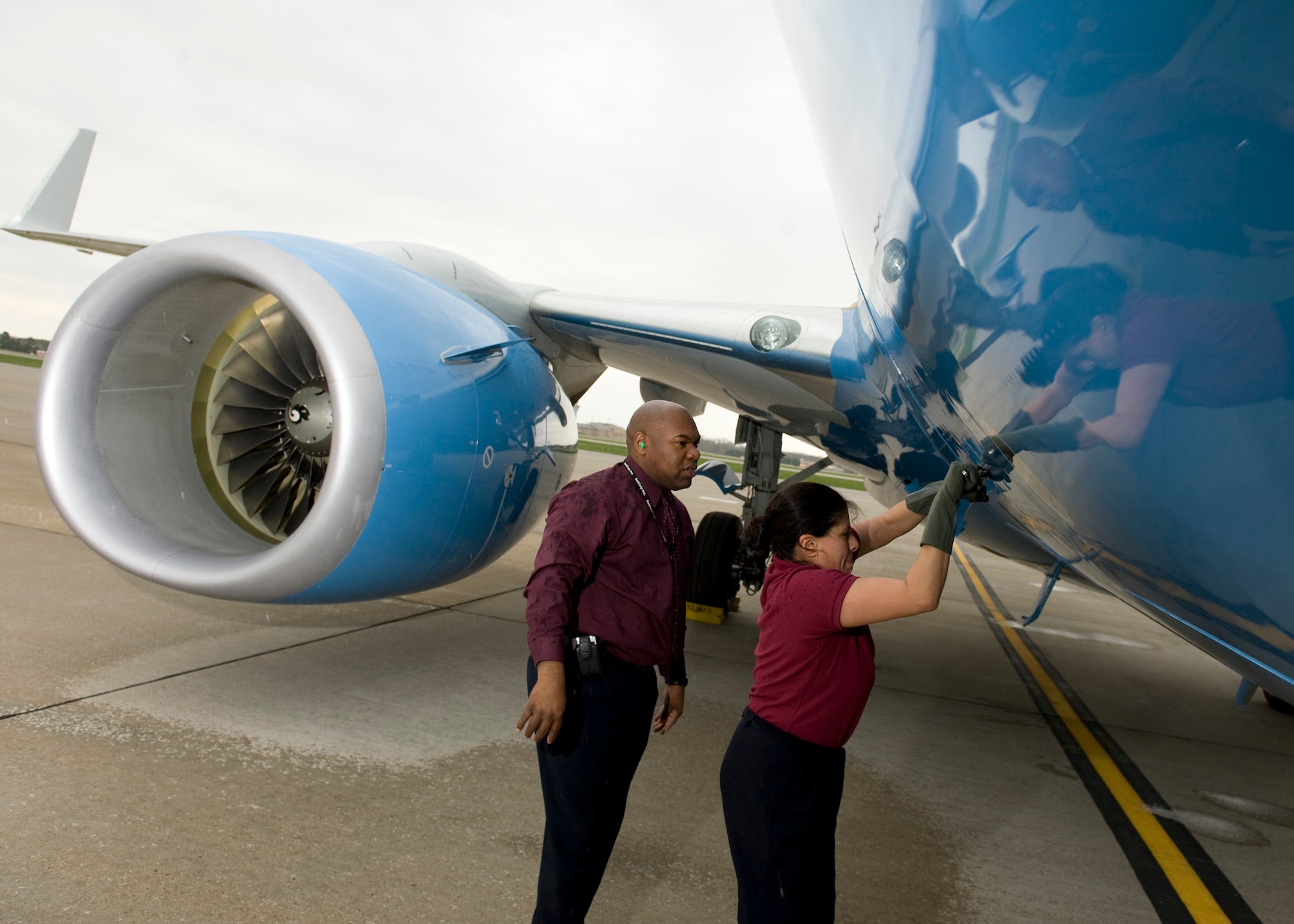 SCOTT AIR FORCE BASE, Ill. --Master Sgt. Ken Posey and Tech. Sgt. Brenda Mejia secure the forward cargo door of a C-40 aircraft during a pre-flight inspection.  Both are executive flight attendants with the 54th Airlift Squadron, a unit that provides precise and reliable airlift for senior leaders.(U.S. Air Force photo/Staff Sgt. Paul Villanueva II)