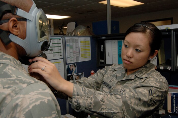 Airman 1st Class Leah Erlandson adjusts the straps on a MCU-2A/P gas mask for a Charleston Airman prior to administering a gas mask fit test at the bioenvironmental flight building here May 5. Airmen go through a gas mask fit test after receiving their mask or after changing sizes to ensure they have a good seal on their mask, making them more confident in wearing their mask if an adverse situation occurs. Airman Erlandson is a bioenvironmental engineering technician assigned to the 437th Medical Group. (U.S. Air Force photo/Staff Sgt. Marie Cassetty)