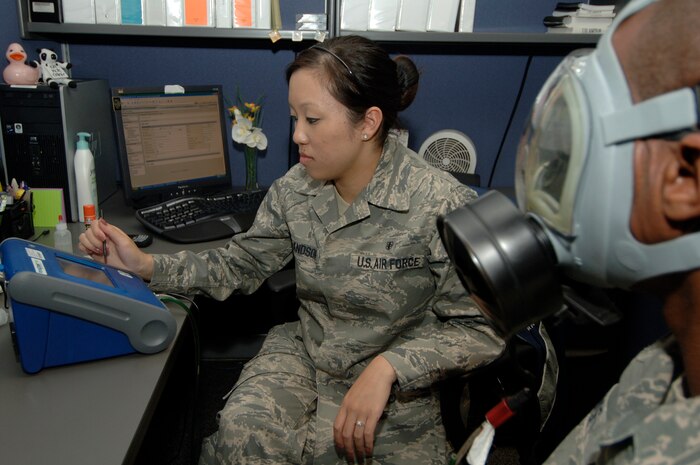 Airman 1st Class Leah Erlandson monitors a 8030 Portacount Pro machine during a gas mask fit test for a Charleston Airman at the bioenvironmental flight building here May 5. The Portacount Pro is designed to measure fit factors of a mask with an efficiency of 99 percent or greater. A fit factor of 100 means that the air inside the gas mask is 100 times as clean as the air outside. Airman Erlandson is a bioenvironmental engineering technician assigned to the 437th Medical Group. (U.S. Air Force photo/Staff Sgt. Marie Cassetty)