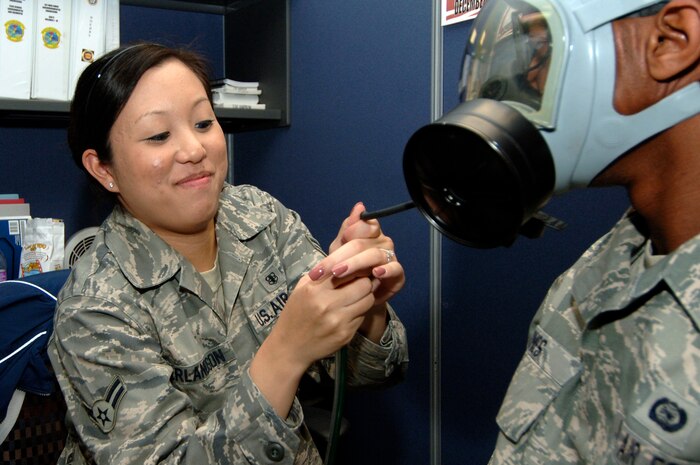 Airman 1st Class Leah Erlandson connects a 8030 Portacount Pro machine to a MCU-2A/P gas mask in order to conduct a gas mask fit test for a Charleston Airman at the bioenvironmental flight building here May 5. The Portacount Pro is designed to measure fit factors of masks with an efficiency of 99 percent or greater by comparing the concentration of microscopic particles outside the gas mask to the concentration of particles that have leaked into the gas mask.  Airman Erlandson is a bioenvironmental engineering technician assigned to the 437th Medical Group. (U.S. Air Force photo/Staff Sgt. Marie Cassetty)