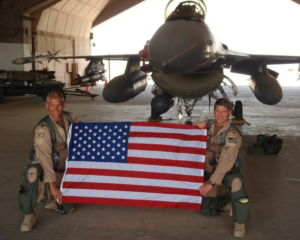 Lt. Col. John Schoettmer and Maj. Scott Cline proudly display the American flag on the 4th of July while deployed