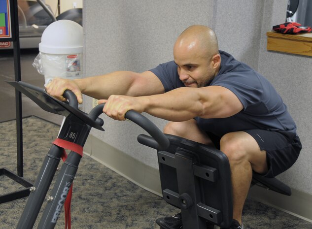 Miguel Acevedo stretches out his lower back in between weight training sets at a flexibility station at the Fitness and Sports Center here May 5. During the stretch, Mr. Acevedo used station to move from a lower back stretch to an upper back stretch. Regular stretching pays off for individuals both in and outside of the gym after a workout and prepares the body for outdoor activity. Mr. Acevedo is an engines technician contract employee. (U.S. Air Force photo/Staff Sgt. Daniel Bowles)