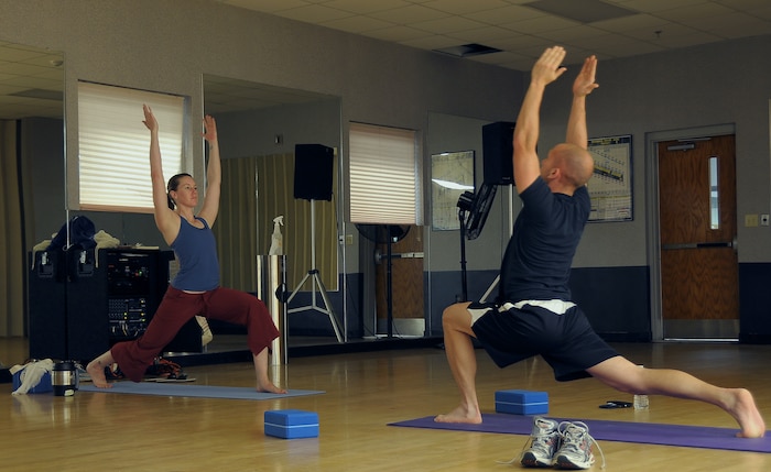 Staff Sgt. Jessica Fruth leads Staff Sgt. Brandon Voges in a lunge exercise during an afternoon yoga session at the Fitness and Sports Center here May 5. During the session, the sergeants performed various exercises aimed at improving flexibility, balance and controlled breathing. Yoga is an excellent option for balancing out an overall workout routine and reducing the risk of athletic injury. Sergeant Fruth serves as a network administrator with the 1st Combat Camera Squadron and Sergeant Voges serves as a fireman with the 437th Civil Engineer Squadron. (U.S. Air Force photo/Staff Sgt. Daniel Bowles)