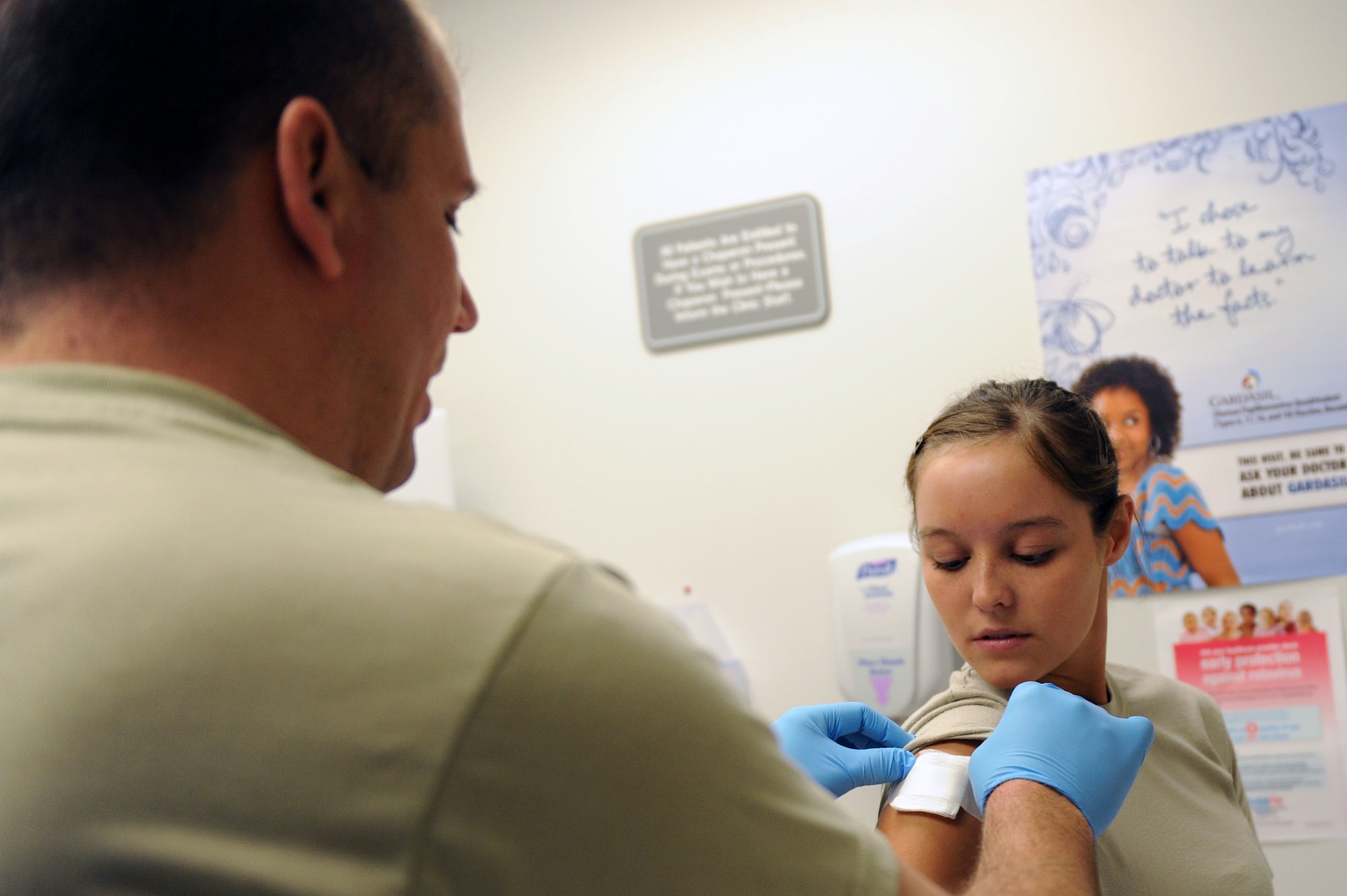 WHITEMAN AIR FORCE BASE, Mo. -- Tech. Sgt Ben Pennington, 509th Medical Operations Squadron, puts a bandage Airman 1st Class Tiffany Casali, 509 Force Support Squadron, after she received a Small Pox shot for her deployment to Kuwait April 22.  (U.S. Air Force photo/ Senior Airman Jason Huddleston)