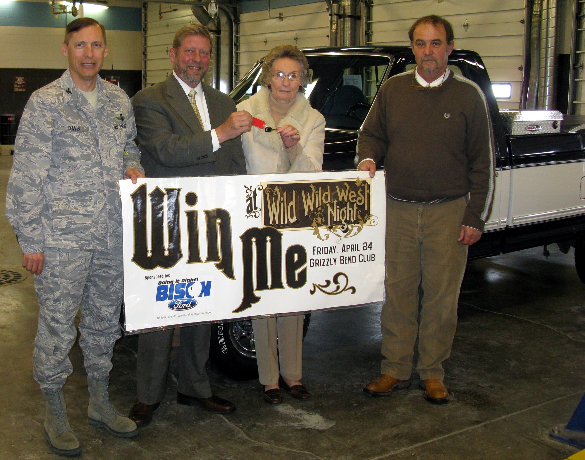 Col. Roderick Davis, 341st Mission Support Group Commander, John Johnson, from Bison Ford, Mary Floyd and Wes Rolfe, from Bison Ford pose for a photo while handing the keys to a 1995 Ford F-150 to Mrs. Floyd, who won the vehicle in a drawing held during Wild West Night April 24 at the Grizzly Bend Club. Mrs. Floyd donated the vehicle to Central Catholic High school in Great Falls. (Courtesy photo)