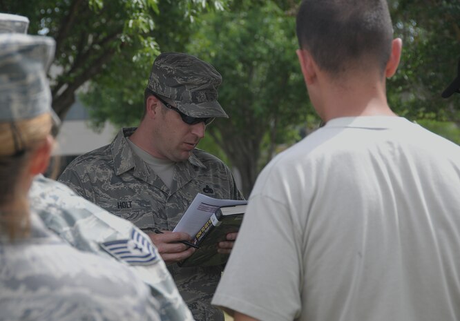 Master Sgt. William Holt reviews a personnel roster outside the 315th Airlift Wing headquarters building here May 4. Sergeant Holt gathered Airmen from the 437th and 315th Aircraft Maintenance Squadrons under the wing of a static display aircraft after a 1,000-foot evacuation distance was implemented due to the discovery of a suspicious package only minutes after the conclusion of an emergency management exercise on base. Sergeant Holt serves as a section chief with the 437 AMXS. (U.S. Air Force photo/Staff Sgt. Daniel Bowles)