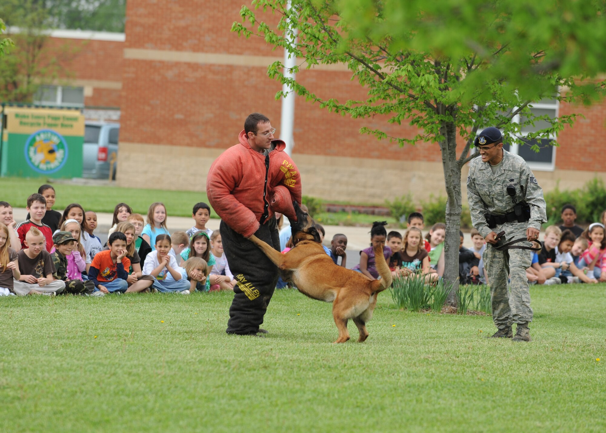 SCOTT AIR FORCE BASE, Ill. --Senior Airman Darren Pretlow, 375th Security Forces Squadron canine handler, gives commands to Roy, a 5-year-old Belgian Malinois working dog, to take down a suspicious person, Tech. Sgt. Henry Lenhardt, 375th Security Forces Squadron working dog trainer, at Scott Elementary May 1. The demonstration showed the abilities of a handler and his working dog.(U.S. Air Force photo/Staff Sgt. Paul Villanueva II) 