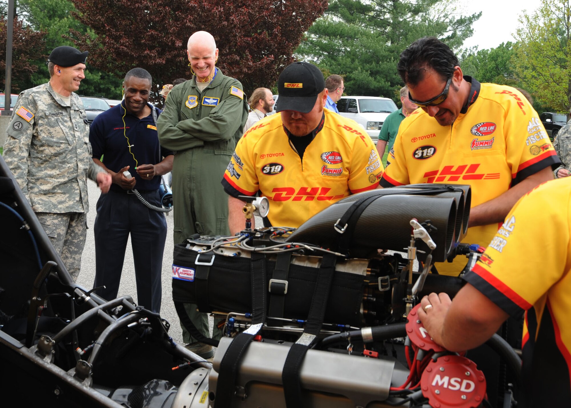 SCOTT AIR FORCE BASE, Ill. --Maj. Gen. William H. Johnson, U.S. Transportation Command chief of staff along with Brig. Gen. Taco Gilbert, Director of Strategic Plans, Requirements and Programs at Air Mobility Command, watch as crew members of the DHL nitro funny car refuel and prepare it for another demonstration April 27 at the Scott Club.(U.S. Air Force photo/Airman 1st Class Wesley Farnsworth) 