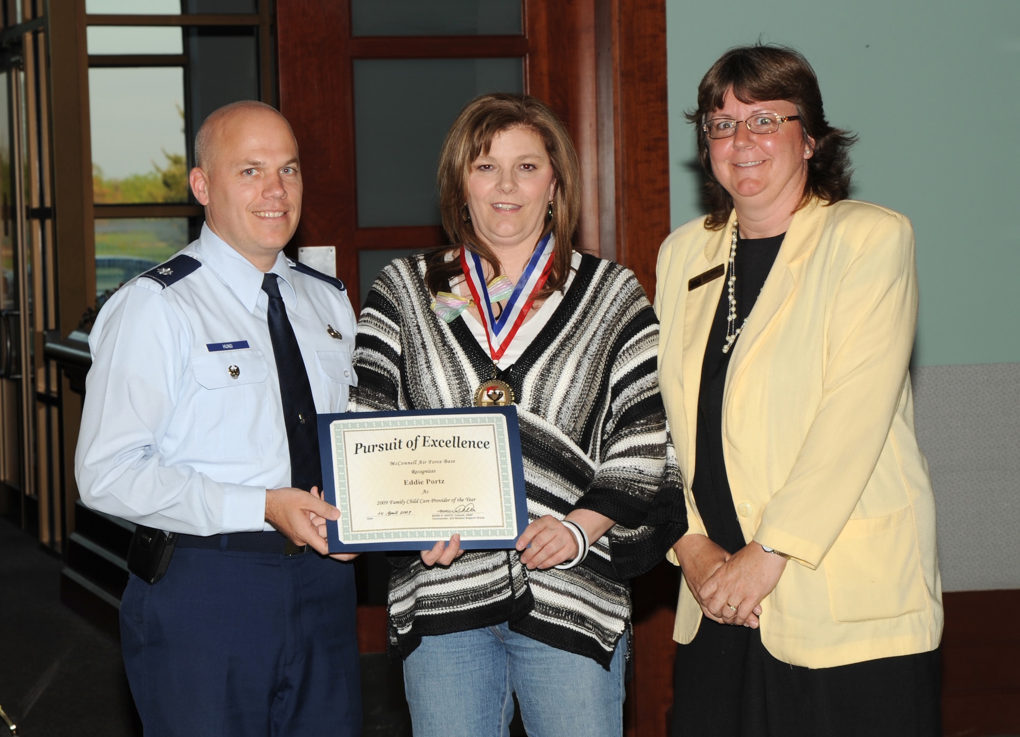 MCCONNELL AIR FORCE BASE, Kan. -- Lt. Col. Roman Hund, 22nd Mission Support Group deputy commander and Mary Reece, 22nd Force Support Squadron, present Eddie Portz with the McConnell Air Force Base Family Childcare Provider of the Year award during Provider Appreciation Day at Signatures, May 4. Provider Appreciation Day is an annual event started by a group of volunteers in New Jersey in 1996 to recognize care givers of children ages 2 weeks to 12 years old. (Photo by Senior Airman Roy Lynch) 