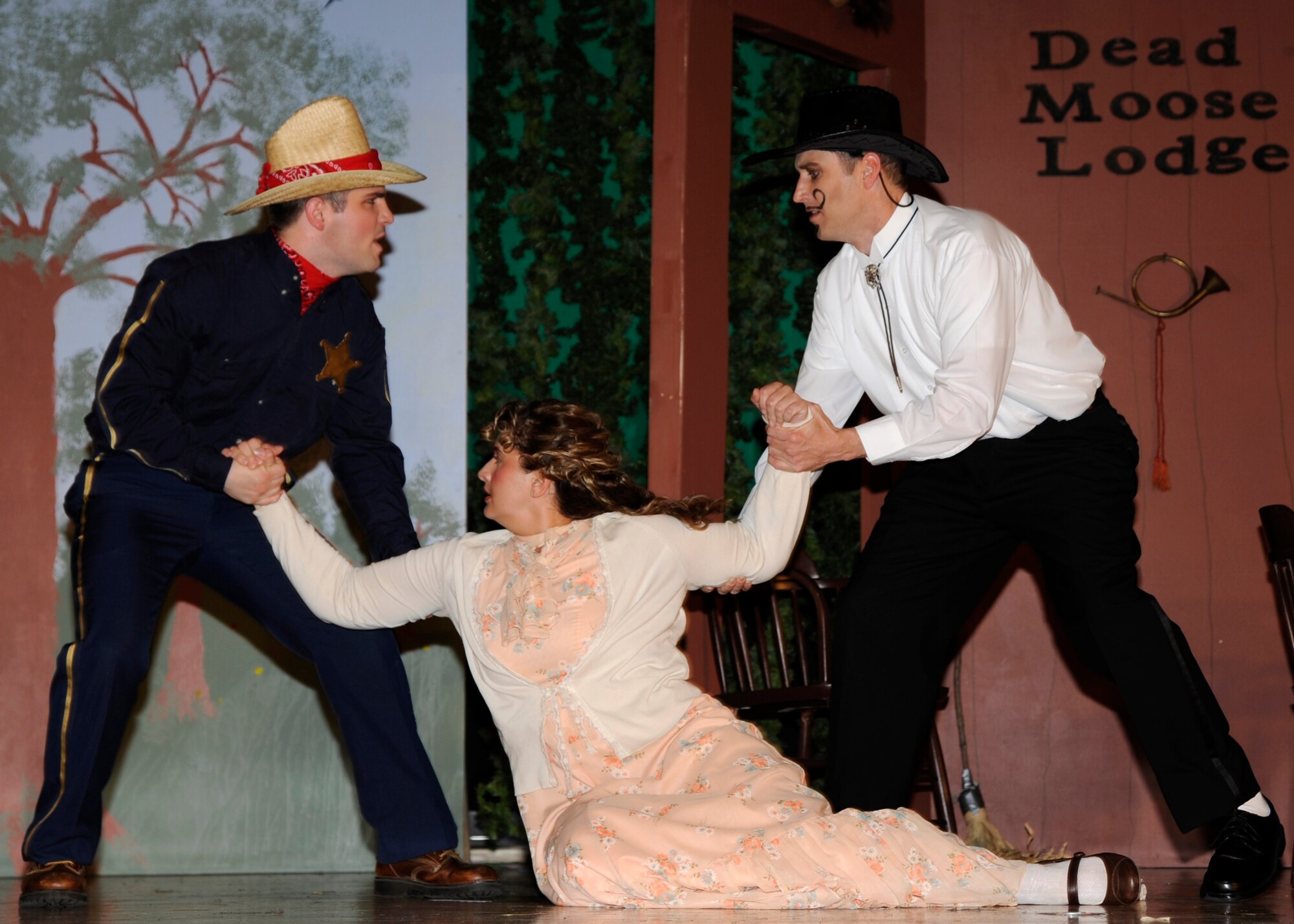 MCCONNELL AIR FORCE BASE, Kan. -- Senior Airman Trevor Winge, 22nd Communications Squadron, as Seymore Stoutfellow, and Master Sgt. Andrew Neeley, 22nd Maintenance Operations Squadron, in the role of Brad Apple, fight over Ms. Marginally Modest, played by Mindi Beyer, Team McConnell family member, during the McConnell Players’ production of “She Was Only Marginally Modest” at the Robert J. Dole Community Center, April 30. In the story, Stoutfellow, was a lawman who sought to bring character Brad Apple to justice. (Photo by Airman 1st Class Justin Shelton) 