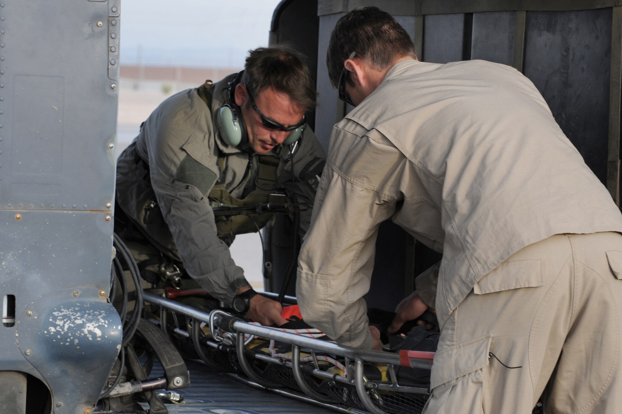 Staff Sgt. Jerry Lennon and Senior Airman David Coval make final adjustments to a litter aboard HH-60G Pave Hawk prior to departing for a rescue mission May 1 at Nellis Air Force Base, Nev. Four helicopters and 24 Airmen from the 58th and 66th Rescue Squadrons deployed to assist in the search for a pilot and passenger who were aboard a motorized sailplane that disappeared from radar April 24 in the Sierra Nevada Mountain Range near Mammoth Lakes, Calif.Sergeant Lenon and Airman coval are pararescuemen with the 58th Rescue Squadron. (U.S. Air Force photo/Senior Airman Nadine Y. Barclay)