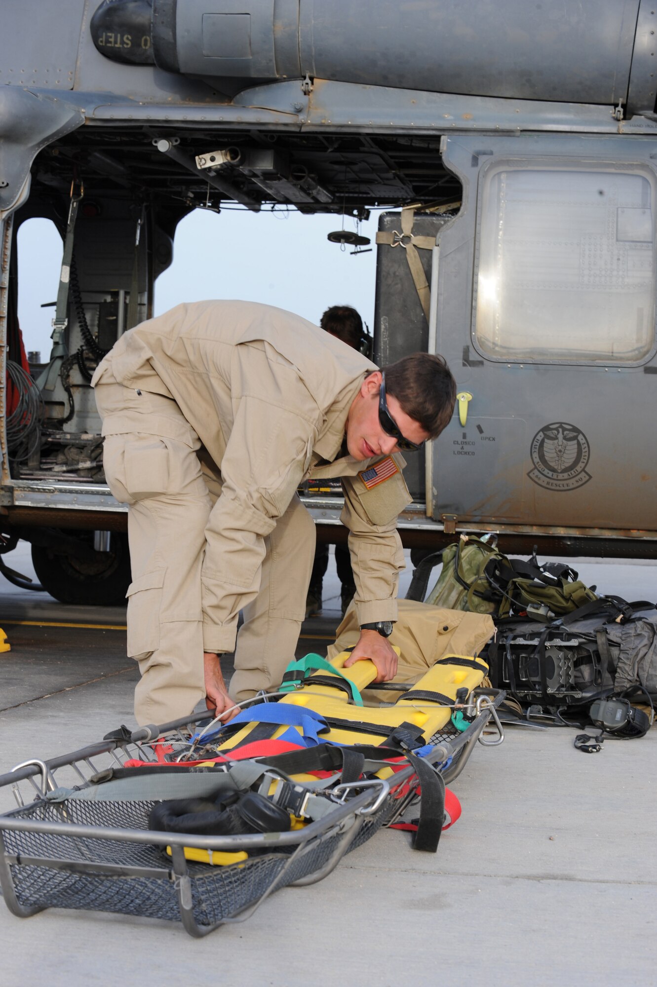 Senior Airman David Coval prepares to load a litter onto an HH-60G Pave Hawk prior to departing for a rescue mission May 1 at Nellis Air Force Base, Nev. Four helicopters and 24 Airmen from the 58th and 66th Rescue Squadrons deployed to assist in the search for a pilot and passenger who were aboard a motorized sailplane that disappeared from radar April 24 in the Sierra Nevada Mountain Range near Mammoth Lakes, Calif. Airman Coval is a pararescueman with the 58th Rescue Squadron. (U.S. Air Force photo/Senior Airman Nadine Y. Barclay)
