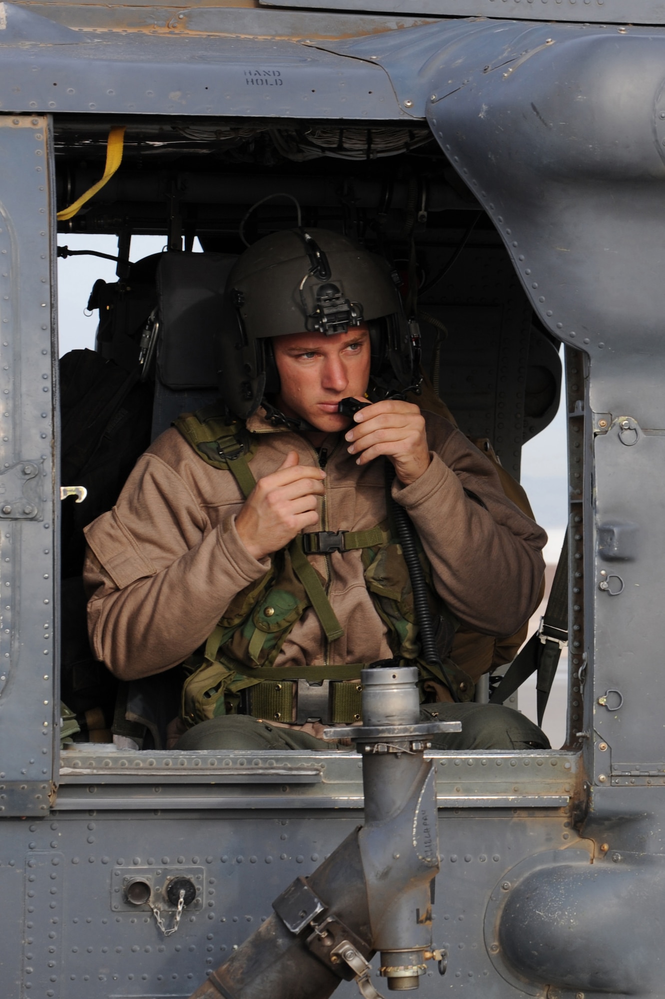 Staff Sgt. Johann Schultz makes final adjustments to his helmet prior to departing for a rescue mission May 1 at Nellis Air Force Base, Nev. Four helicopters and 24 Airmen from the 58th and 66th Rescue Squadrons deployed to assist in the search for a pilot and passenger who were aboard a motorized sailplane that disappeared from radar April 24 in the Sierra Nevada Mountain Range near Mammoth Lakes, Calif. Sergeant Schultz is an an HH-60G aerial gunner with the 66th Rescue Squadron. (U.S. Air Force photo/Senior Airman Nadine Y. Barclay)

