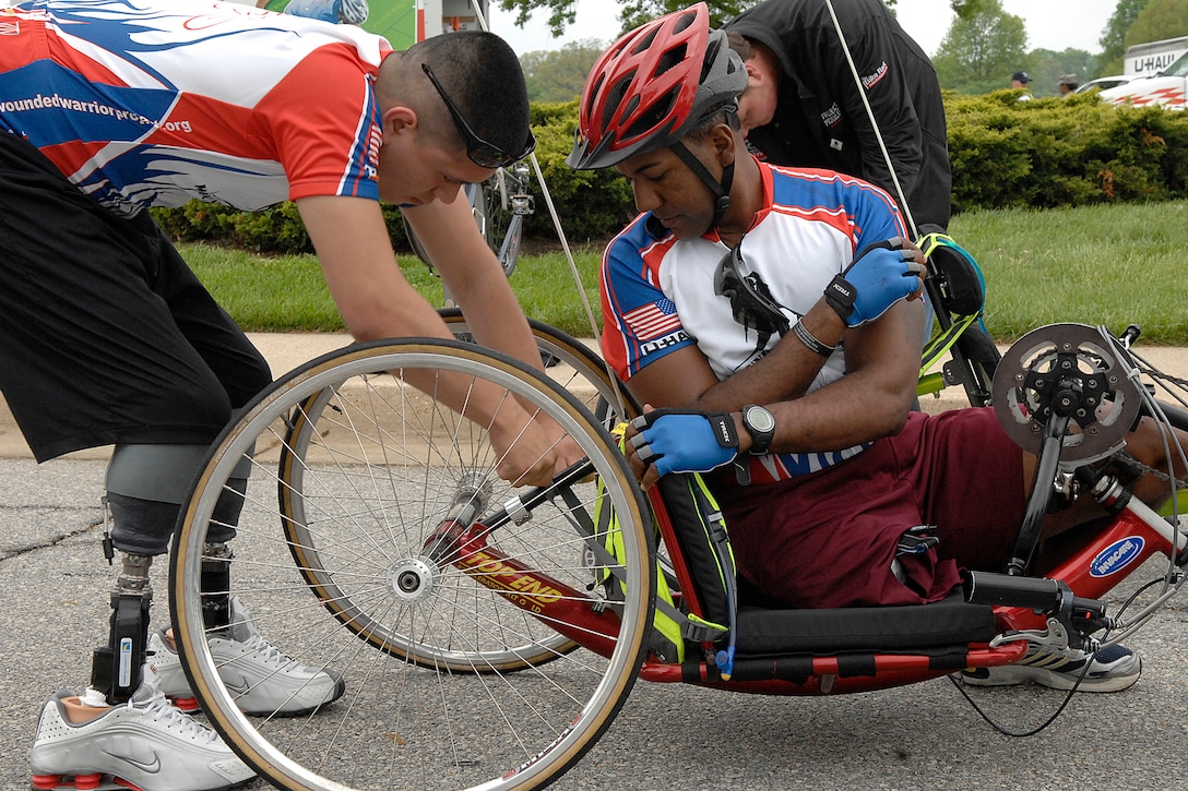 Lance Corporal Jose Casca, an infantry from the 3rth Battalion 6th Marine, helps Sergeant Alfredo Delossantos, a Civil Affair Specialist from 98th Army Civil Affair Battalion, with his vehicle prior to the start of the ride, Andrews Air Force Base Md., on May 1, 2009. The wounded warriors rode from Andrews to Annapolis, Md., as a part of a four day event to raise awareness of issues that veterans are challenged with when they return wounded from the war and for many, the soldier ride provides an important step in their return to an active lifestyle. (U.S. Air Force photo by: Senior Airman Giang Nguyen)