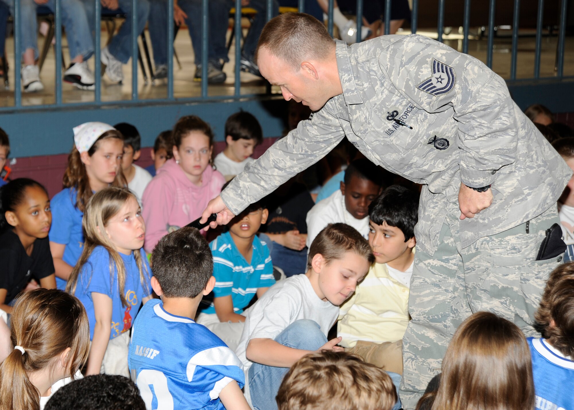 MCCONNELL AIR FORCE BASE, Kan. -- Tech. Sgt. Daniel Bechtel, 22nd Security Forces Squadron kennel master, answers questions about military working dogs during a demonstration at Wichita Collegiate School, April 24. More than 200 students from first through fourth grades were present for the demonstration. The students spent the past year raising a golden retriever to be used as a seeing-eye dog. (Photo by Airman 1st Class Justin Shelton) 