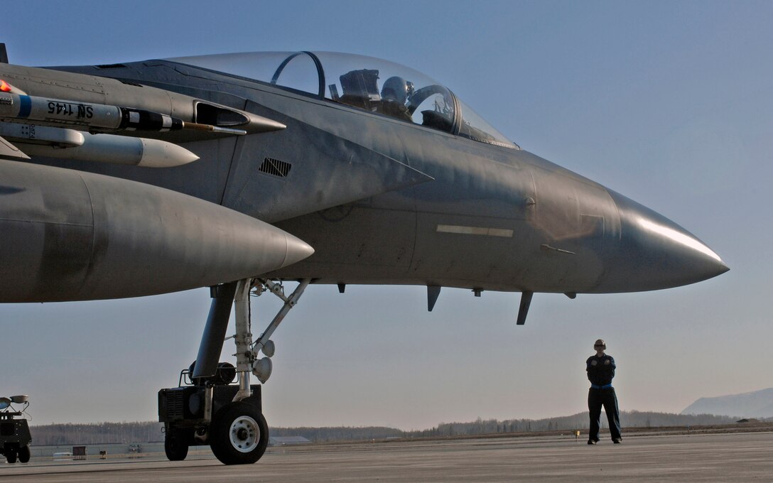 An F-15 Eagle maintainer waits to flag a fighter participating during Red Flag-Alaska 2009 April 30 at Elmendorf Air Force Base, Alaska. This exercise enabled flying squadrons to enhance their fighting capabilities in simulated combat sorties in a realistic threat environment. The 10-day exercise ended May 1. (U.S. Air Force photo/Senior Airman Laura Turner)