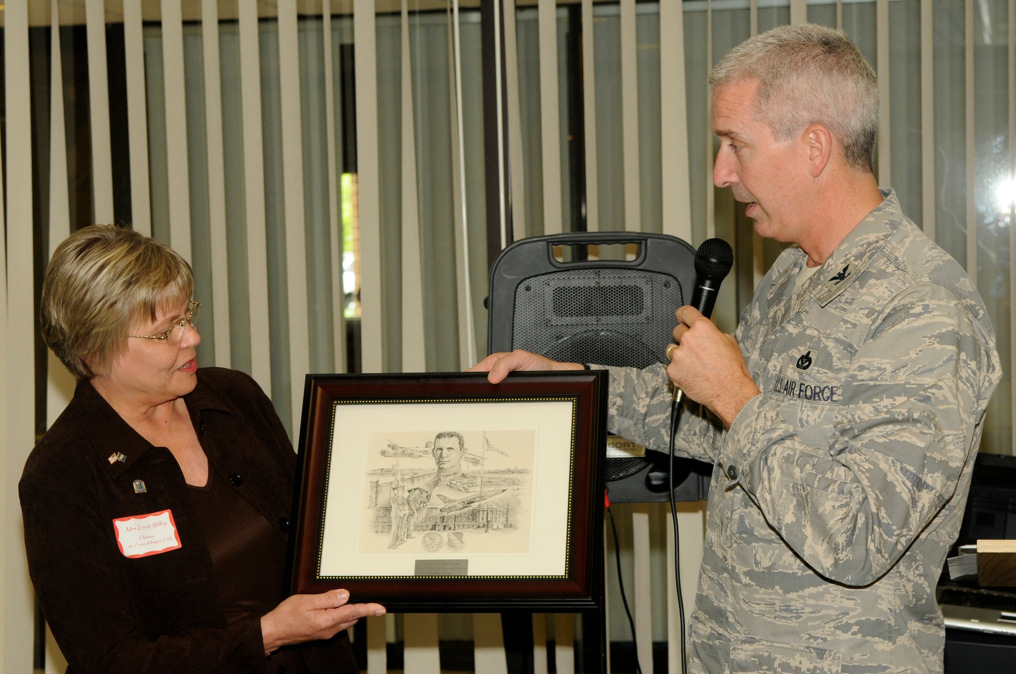 Col. Jon A. Roop, 11th Wing commander, presents Linda Willey, Air Force Arlington Ladies Chairperson, with a plaque honoring the them for 60 years of service. Today, there is an Air Force Arlington Lady or Gentleman present at each service held for active duty, retired or veteran servicemembers buried at Arlington. As part of the ceremony, the attending committee member presents a sympathy card to the surviving family and friends from the Air Force chief of staff as well as a personal note of condolence. If no loved ones are present, a letter describing the ceremony is written and mailed along with the notes. (U.S. Air Force photo by Staff Sgt. Raymond Mills)