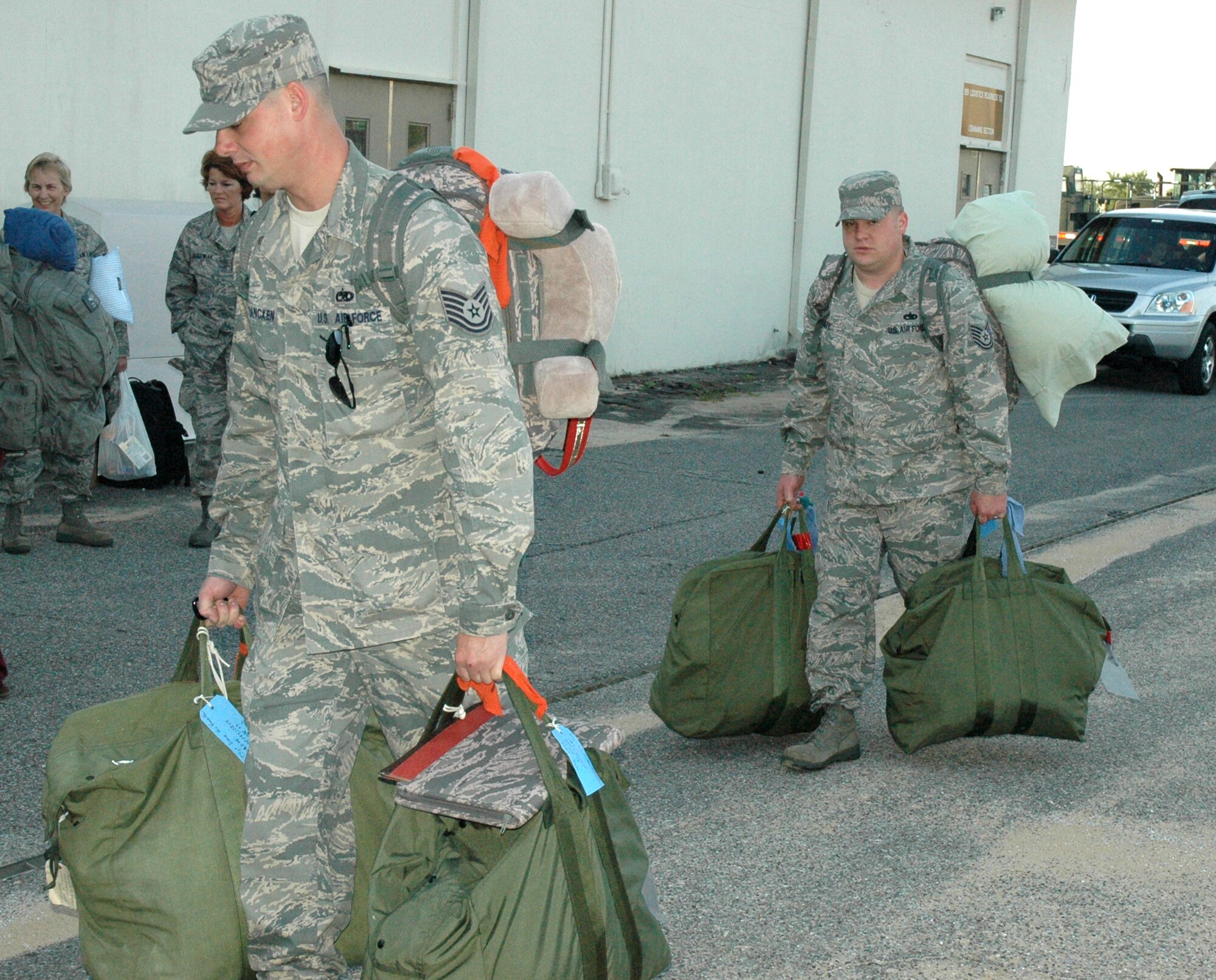 DUKE FIELD, Fla. – Tech. Sgts. Duane Vanvrancken and Clayton White, 919th Maintenance Squadron integrated avionics system technicians, carry their bags to check in at the 919th Logistics Readiness Squadron hangar at Duke Field.  They gathered in the early morning hours with several other Duke Field reservists waiting to depart for a deployment in support of overseas contingency operations.  The reservists checked and loaded their bags onto a truck before saying goodbye to friends and family that had come to see them off. (U.S. Air Force photo/Staff Sgt. Jon McCallum)  