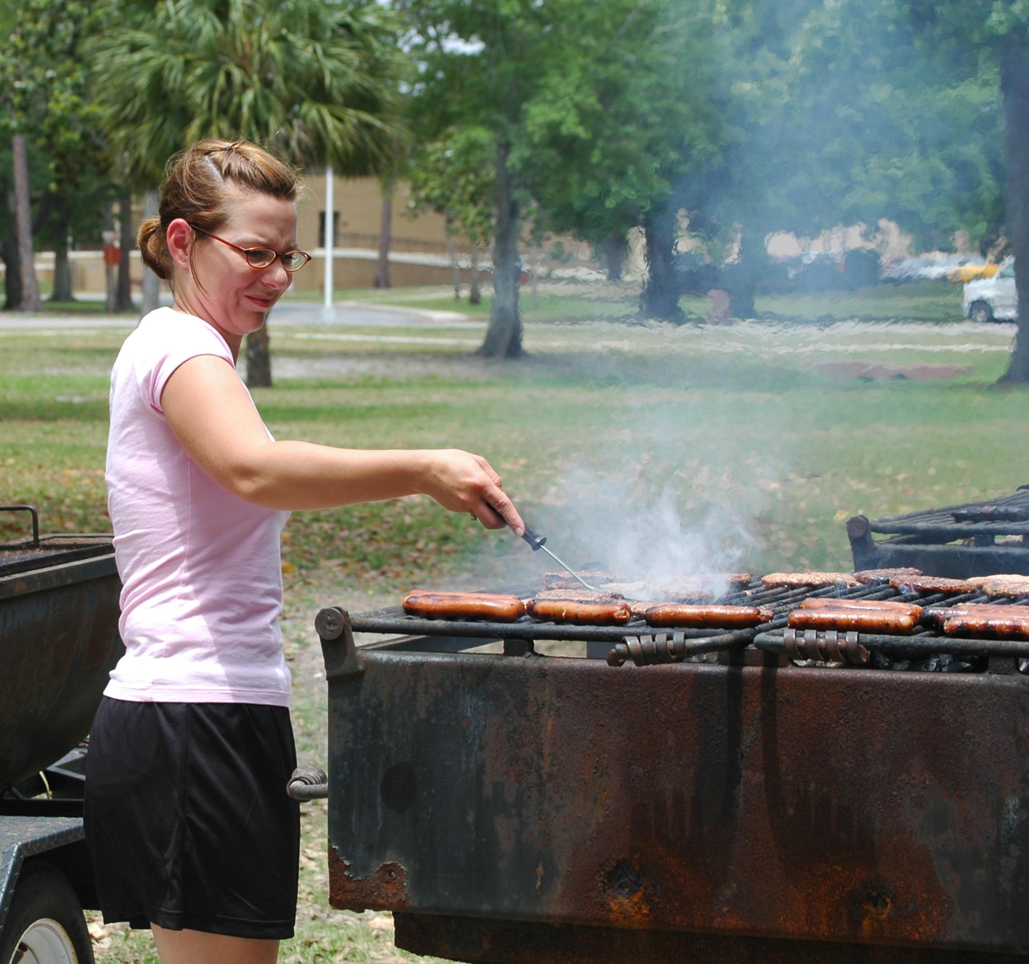 Staff Sgt. Sally Mellen, 325th Security Forces Squadron Command Section NCO in charge, grills hamburgers and hot dogs May 5 at Tyndall Air Force Base, Fla.'s Heritage Park. The lunch was provided to 10 youths involved with the Liberty Unit for Specialized Treatment, a juvenile delinquency program. The teenagers were chosen based on their good conduct through the program for a period of at least two months and two weeks. (U.S. Air Force photo/Staff Sgt. Joshua Stevens) 