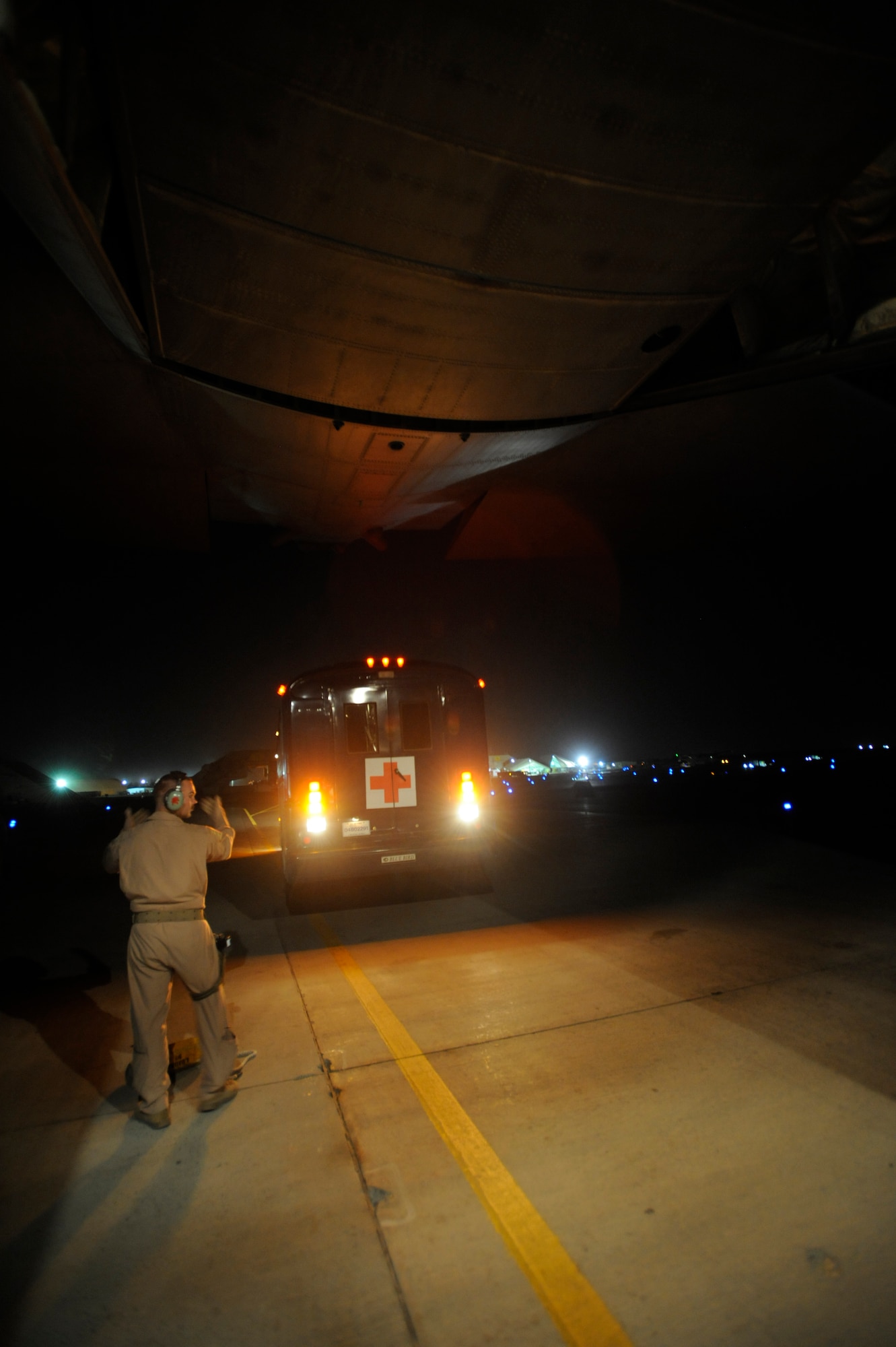 U.S. Air Force Staff Sgt. Josh Walker, a C-130 Loadmaster from the 746th Expeditionary Airlift Squadron, Southwest Asia, backs a medical bus to the rear of the aircraft to cross load patients during aeromedical operations on April 23, 2009, in support of Operation Iraqi Freedom.  (U.S. Air Force photo by Staff Sgt. James L. Harper Jr.)Released