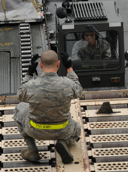 YOKOTA AIR BASE Japan -- Staff Sgt. Jesus Rivera (foreground) spots Senior Airman Christopher LiVigni, as he drives a 60K loader to a loading dock May 6 during the 730th Air Mobility Squadron's Transportation Round-Up. The Round-Up is designed to provide a healthy competition among squadron members and is focused on the core capabilities of air mobility Airmen. (U.S. Air Force photo/Airman 1st Class Devin Doskey)