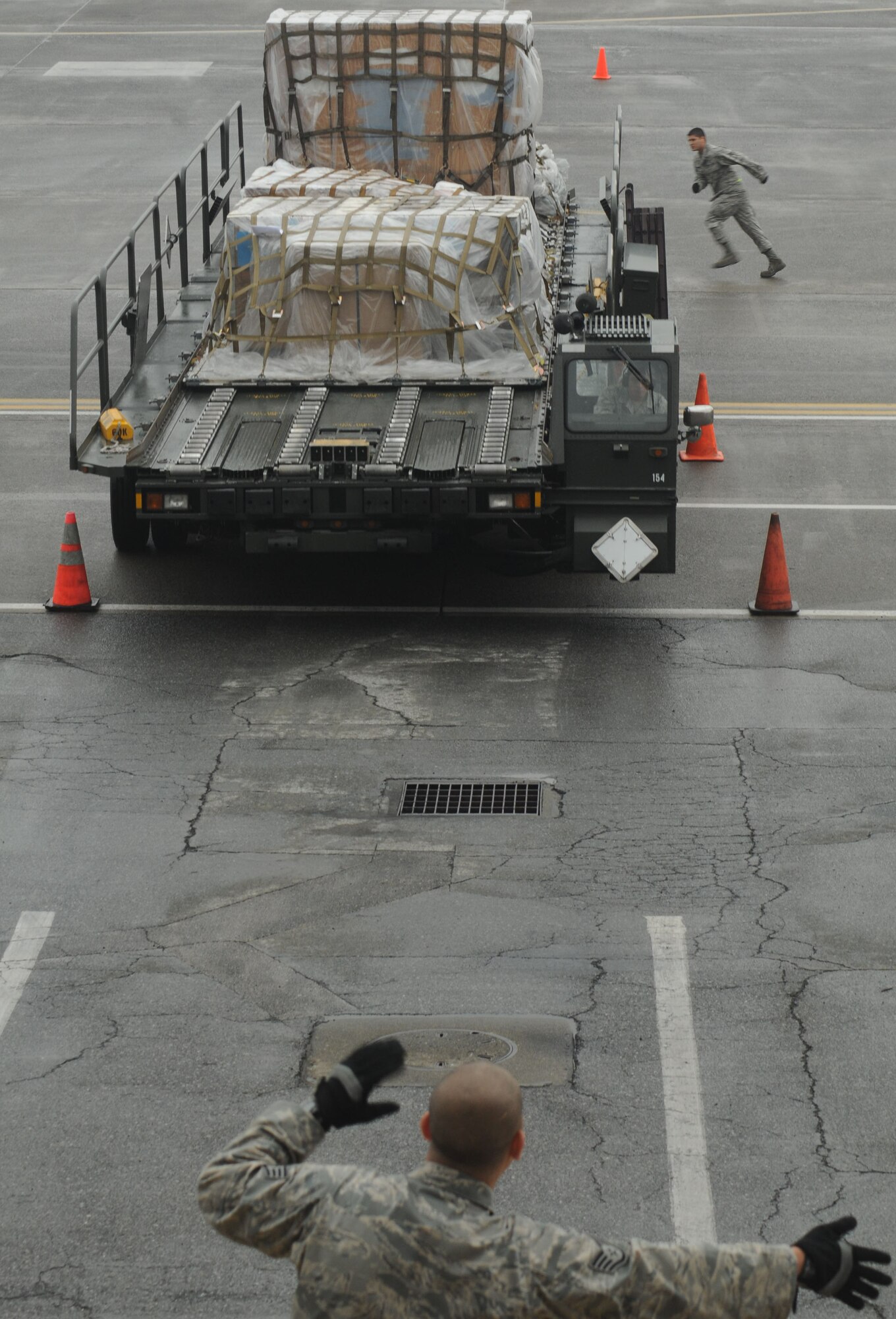 YOKOTA AIR BASE Japan -- Staff Sgt. Jesus Rivera (foreground) and Senior Airman Joseph Needham, spot Senior Airman Christopher LiVigni, as he drives a 60K loader through an obstacle course May 6 during the 730th Air Mobility Squadron's Transportation Round-Up. The Round-Up is designed to provide a healthy competition among squadron members and is focused on the core capabilities of air mobility Airmen. (U.S. Air Force photo/Airman 1st Class Devin Doskey)