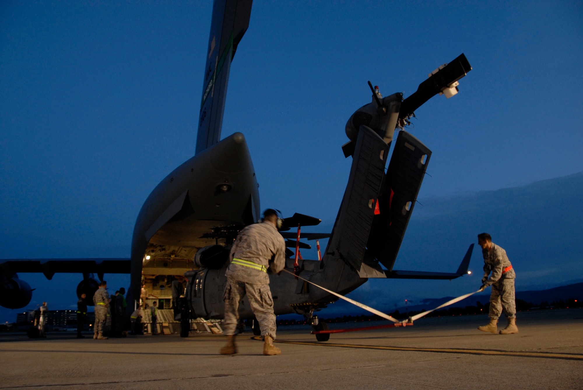 129th Maintenance Group personnel direct an HH-60G Pave Hawk rescue helicopter into a C-17 Globemaster.  More than 50 Airmen and three Pave Hawks from the 129th Rescue Wing deployed to Afghanistan May 3, 2009. (U.S. Air Force photo by Tech. Sgt. Ray Aquino)