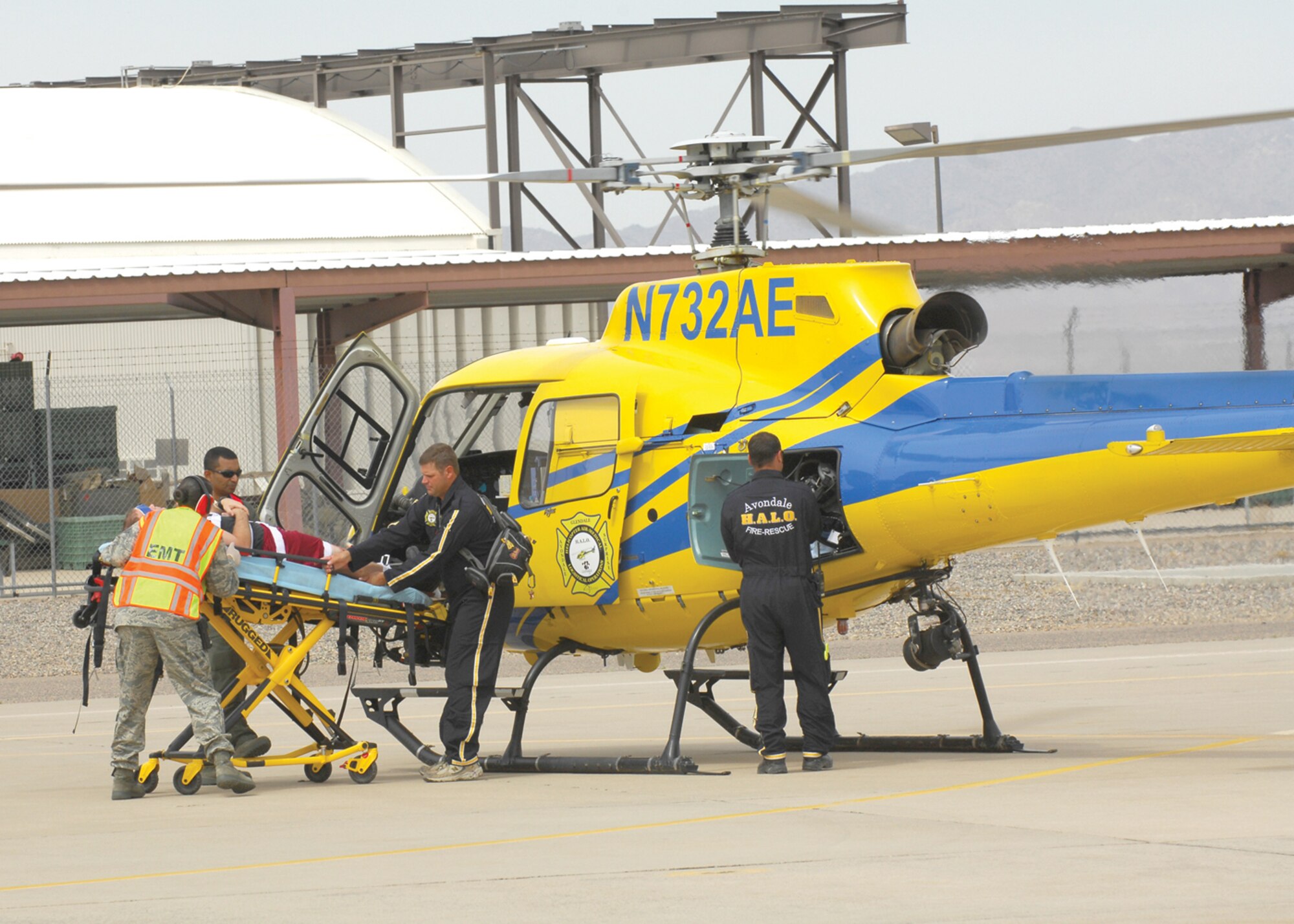 Luke Air Force Base emergency medical technicians work with the Avondale Air Ambulance to load a simulated patient into a helicopter during the major accident response exercise Tuesday. (U.S. Air Force photo/Tech Sgt. Raheem Moore.)