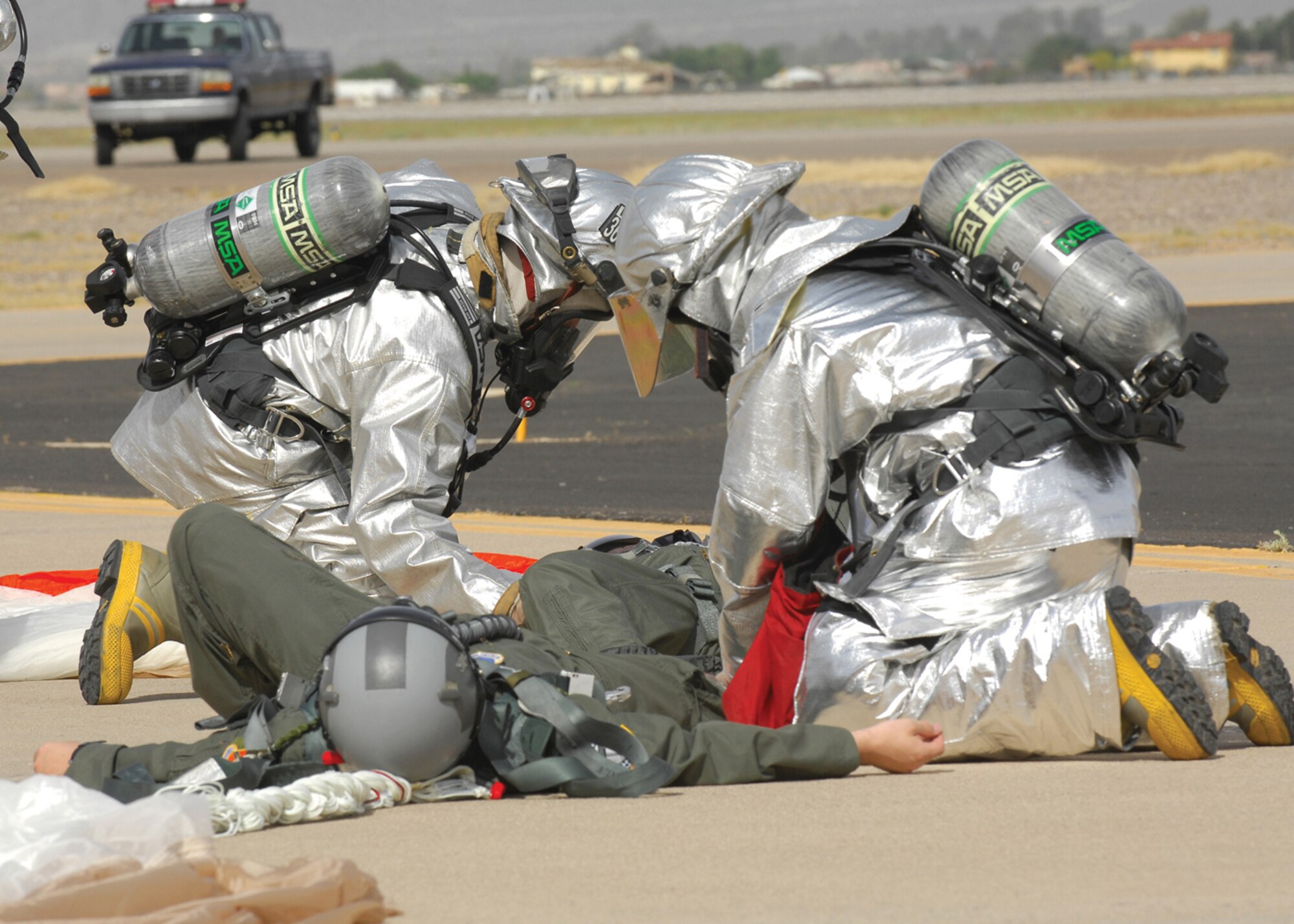 Firefighters from the Luke Air Force Base fire department check the vital stats of two ejected pilots during the major accident response exercise at Luke Air Force Base.(U.S. Air Force photo/ Tech Sgt. Raheem Moore.)
