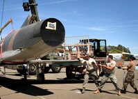 From left to right, 60th Maintenance Squadron member, Airman First Class Michael McKenney, along with 349th Aircraft Maintenance Squadron member's,  Technical Sergeant Justin Nagel and Staff Sergeant Chia Hsu, help reassemble a F-100 Super Saber fighter jet in preparation for transport to the Travis Air Museum April 17th, 2009. The F-100 Super Saber, which arrived from Lackland Air Force Base in Texas, was the first jet aircraft to break the sound barrier in level flight. (U.S. Air Force photo by Civ/Diane DeRemer)