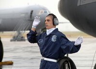 Airman First Class Thomas Shook from the 60th Aerial Port Squadron directs a staircase truck up to the door of a KC-10 Aircraft at Travis Air Force Base California.  A1C Shook is a member of the Elite Staircase Support Team, which is assigned to the arrivals and departures of distinguished guests visiting Travis.  (U.S. Air Force photo by Civ/Nan Wylie)