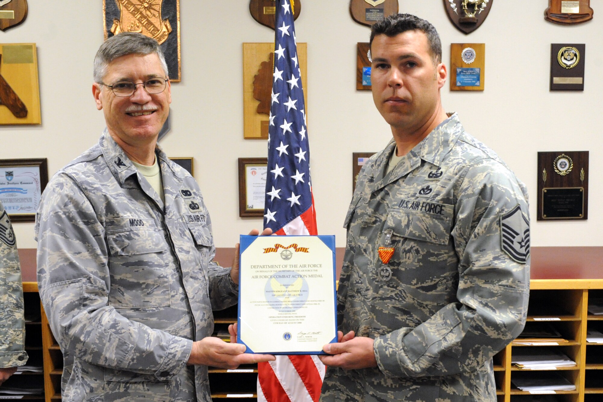 Col. Charles Mood, 419th Mission Support Group commander, presents Master Sgt. Matthew Hill, 419th Civil Engineer Squadron, with the Air Force Combat Action Medal May 2. Sergeant Hill was honored for his actions during an Afghanistan deployment when his patrol came under heavy enemy fire.  Sergeant Hill repelled the attack and assisted a wounded soldier. He is an Explosive Ordinance Display Team Leader in the Active Guard Reserve at Nellis Air Force Base, Nev. (U.S. Air Force photo/Staff Sgt. Kyle Brasier)