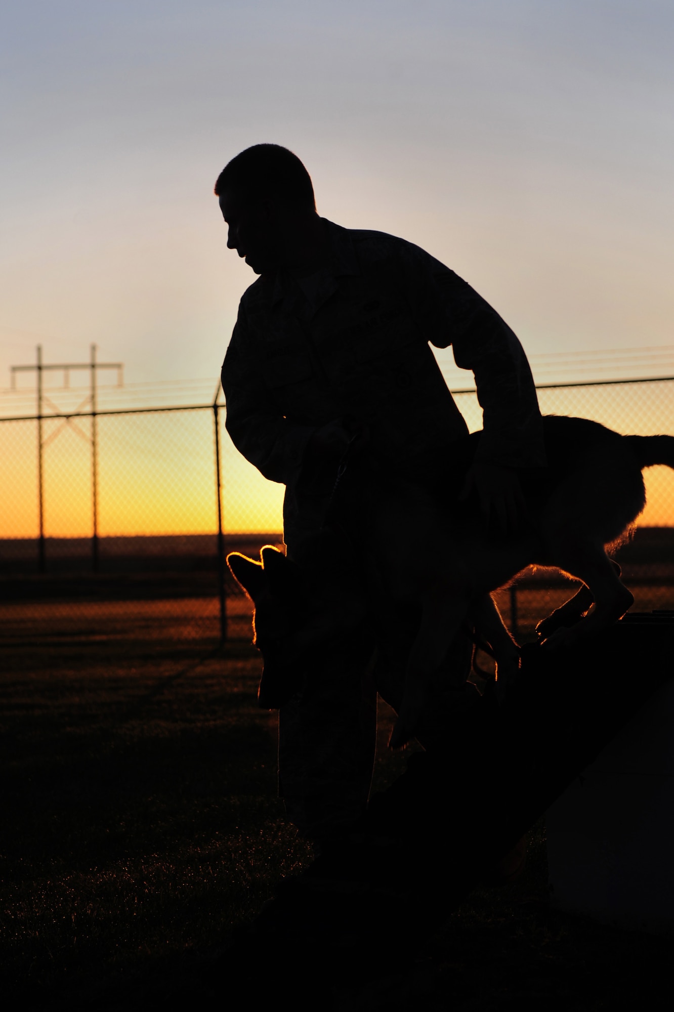 Senior Airman William Knight, 28th Security Forces Squadron dog handler, works on obedience training with Rex, a 28 SFS military working dog in an obstacle course, here, May 7.  Dog handlers perform training with their dogs daily to ensure deployment and real world readiness. (U.S. Air Force photo/Airman 1st Class Joshua J. Seybert)