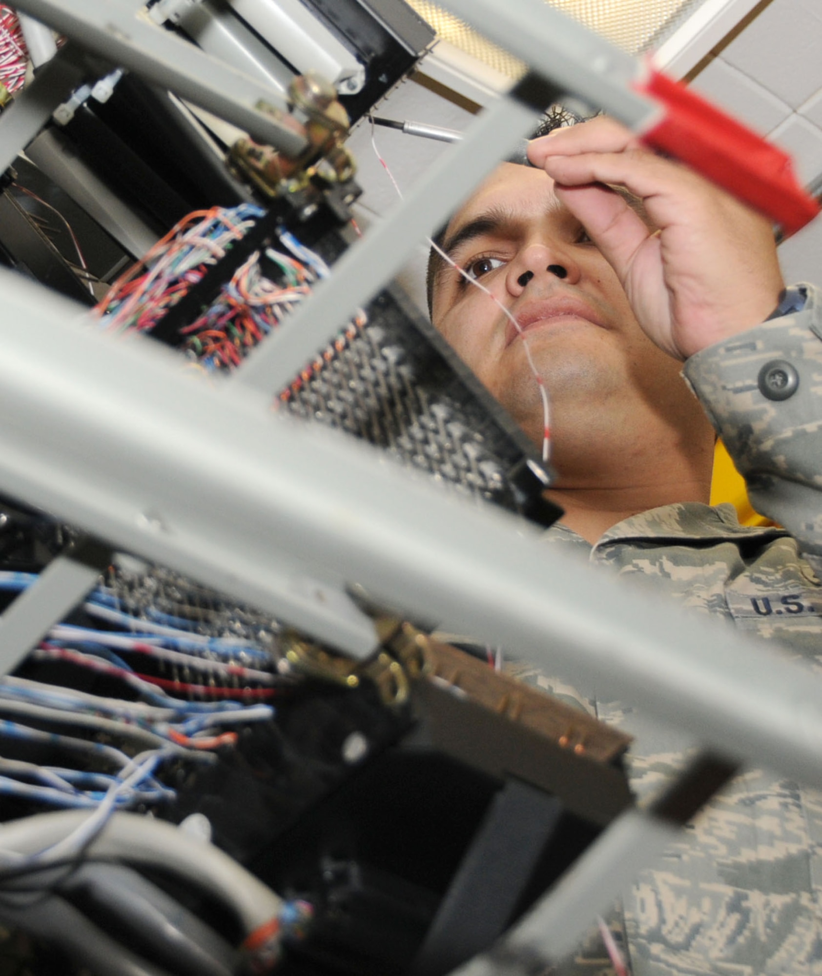 Tech. Sgt. Fernando Duque, network infrastructure assistant noncommissioned officer in charge, replaces attaches modem wiring in the telephone maintenance building for network connections to remote user buildings, April 29.  Sergeant Duque was recognized by the Innovative Development through Employee Awareness Program for his suggestion to replace some old network equipment with new equipment.  His IDEA suggestion increases network speed a minimum of 250 percent and saved the Air Force approximately $250,000.  (U.S. Air Force photo by Kemberly Groue)