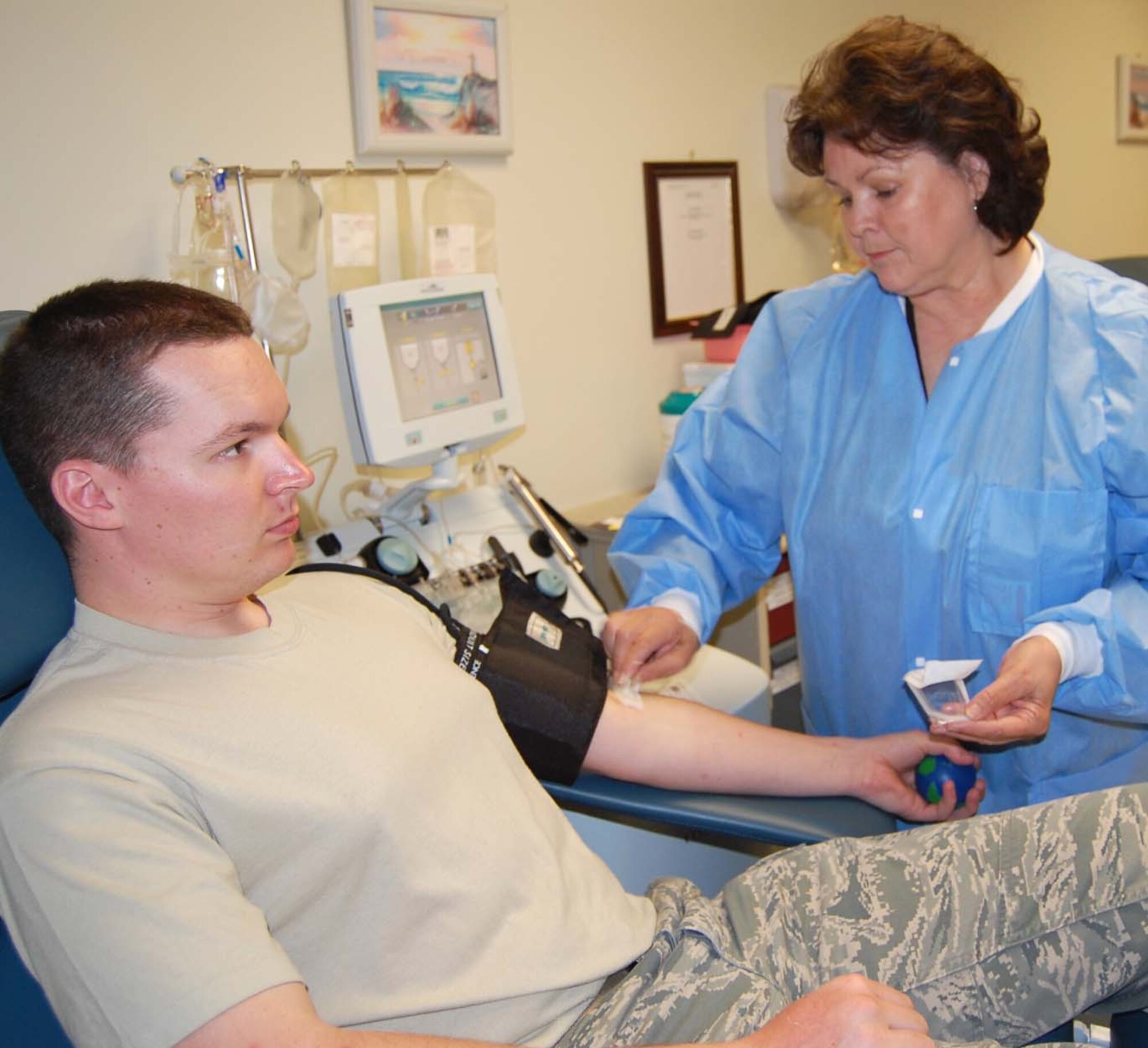 Ms. Weatherly prepares Airman 1st Class Marthinus Taljaard, 81st MDTS, for platelet donation.  This was the second time he had participated in the apheresis process.  (U.S. Air Force photo by Steve Pivnick)