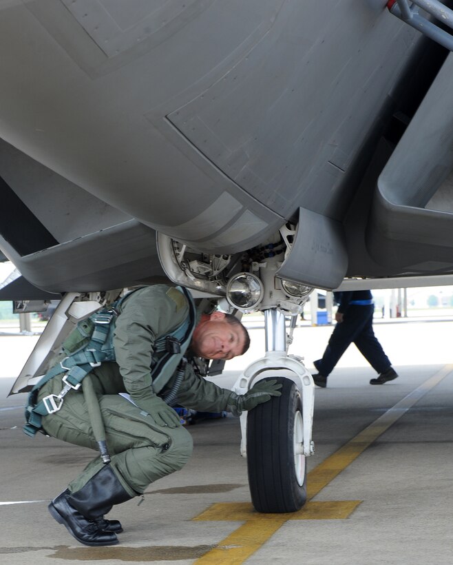 LANGLEY AIR FORCE BASE, Va. -- Brig. Gen. Mark A. Barrett, 1st Fighter Wing commander, inspects the landing gear on an F-22A Raptor.  This is General Barrett's final flight as the 1st Fighter Wing commander.  (U.S. Air Force photo/Airman 1st Class Zachary Wolf)
