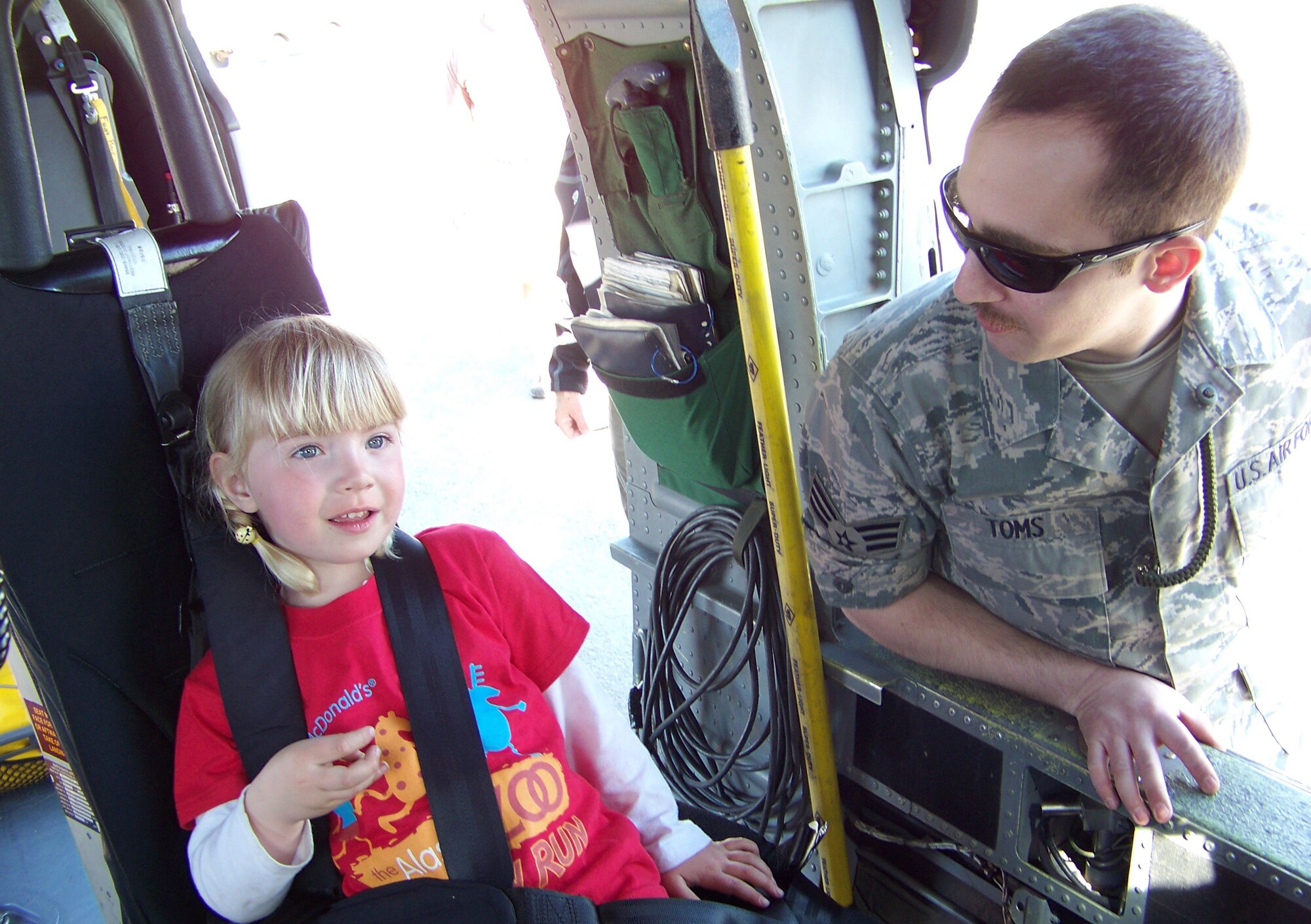 ELMENDORF AIR FORCE BASE, Alaska -- Senior Airman Scott Toms, 176th Aircraft Maintenance helicopter mechanic with the Alaska Air National Guard, gave a tour of the HH-60 Pave Hawk to Isabella Moore, 3, during the 12th Annual Alaska State Aviation Trade Show & Conference at the Ted Stevens Anchorage International Airport in Anchorage, Alaska, May 2-3. Isabella’s father, U.S. Marine Corps Capt. Tyler Moore, is currently deployed to Iraq from the Marine Corps Air Ground Combat Center in Twentynine Palms, Calif. Other Air Force aircraft on display included the 477th Fighter Groups F-22A Raptor, a C-17, C-130H and HC-130 from the Alaska ANG’s 176th Wing, and a T-38C from Randolph Air Force Base, Texas.  (U.S. Air Force photo/Staff Sgt. Andrea Knudson)