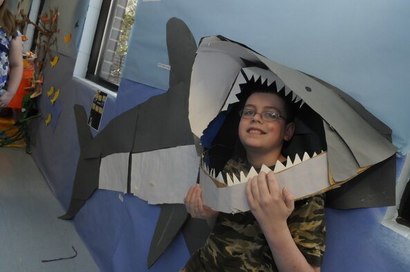 Preston Salazar, Robins Elementary 5th grade student, puts his head in the mouth of the Great White Shark displayed in the hallway. U. S. Air Force photo by Sue Sapp