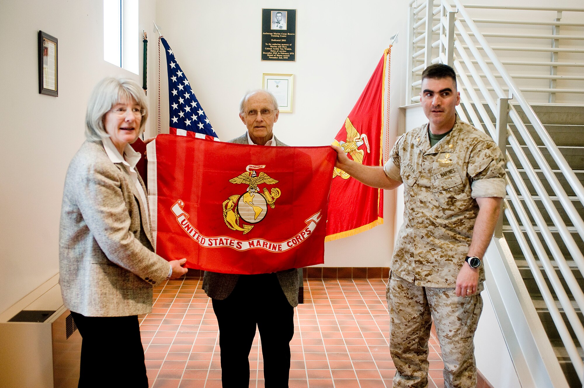 Maj. William Allen presents the Marine Corps colors, signed by Lima Company, 3rd Battalion, 25th Marines from Ohio, to Mrs. Sharon Long, mother of fallen Marine Lance Cpl. Grant Fraser. Fraser who was from the Anchorage area attended the University of Alaska Anchorage for one semester, when he realized college life wasn't the challenge he was seeking. 

So, he enlisted into the Marine Corps and became part of the Echo Company, 4th Reconnaissance Battalion (now Delta Company, Anti-Terrorism Battalion) located between Elmendorf and Fort Richardson. While deployed in Iraq, Fraser and 13 fellow Marines were killed in action Aug. 3, 2005 when the Amphibious Assault Vehicle they were in struck a roadside bomb. Mrs. Long said, "We are gratified that the unit and his fellow Marines continue to remember him and to stay in touch with the family, it's the stories and those connections that keep him alive." (U.S. Air Force photo/Senior Airman Jonathan Steffen)